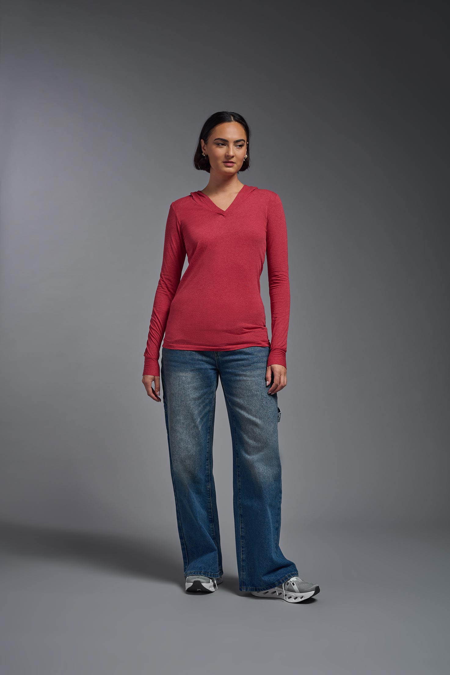 A female model wearing the women's Heather Hoodie Shirt in the color dark heather red, made out of 88% polyester and 22% treated cotton, showing the relaxed fit from a front view. This hoodie shirt is comfortable and made in the USA. #dark-heather-red