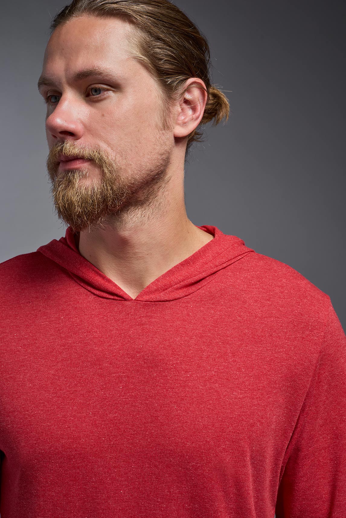 A male model wearing the men's Heather Hoodie Shirt in the color dark heather red, made out of 88% polyester and 22% treated cotton, showing the relaxed fit from a closeup front collar view. This hoodie shirt is comfortable and made in the USA. #color_dark-heather-red