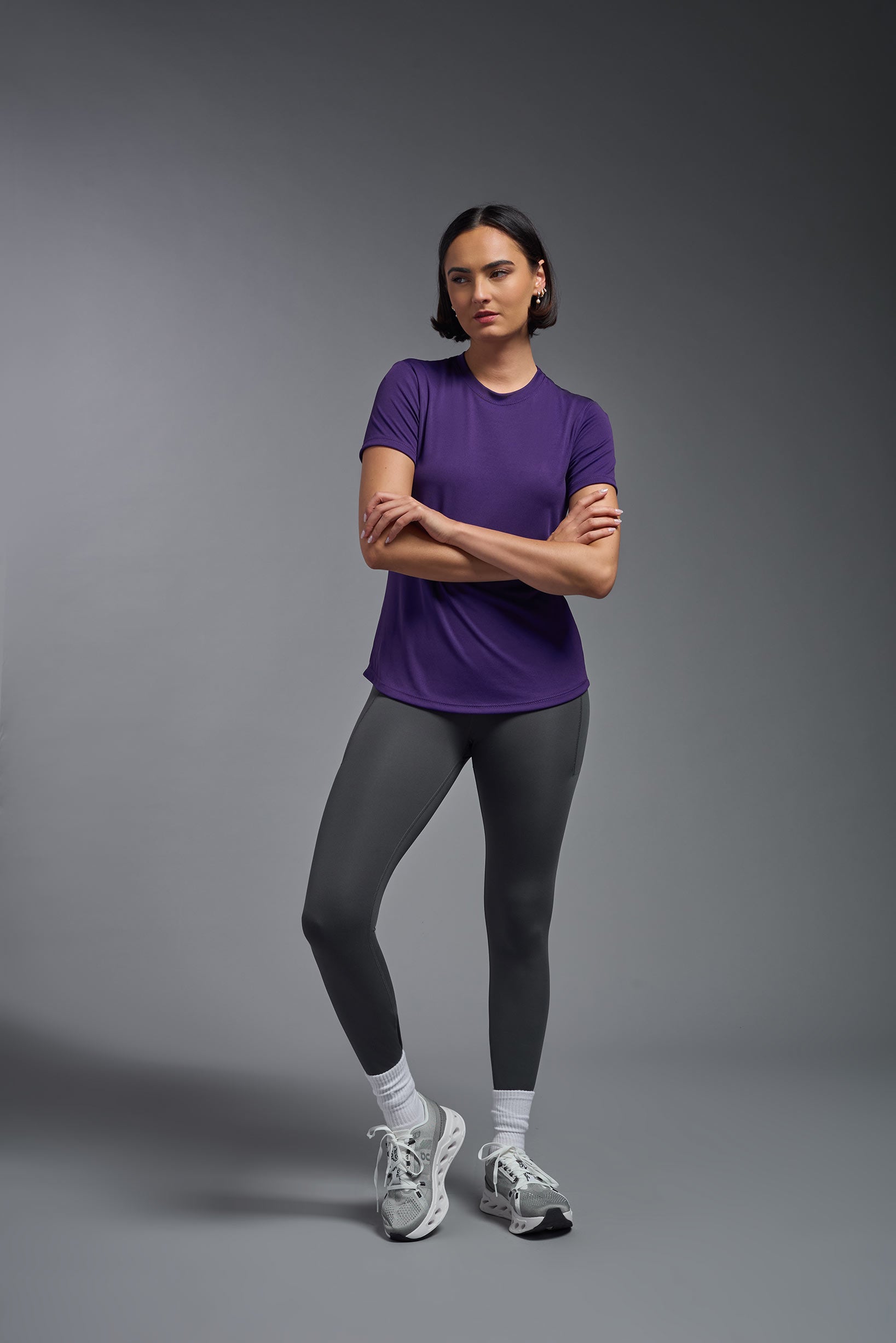 A female model wearing the women's DriMax Crewneck Expert Tee in the color dark purple, made out of 100% polyester, showing the relaxed fit from a front view. This shirt is quick-drying, moisture-wicking, offers up to 30 upf protection and is made in the USA. #deep-purple