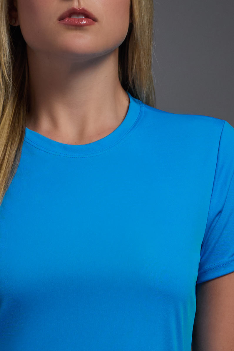 A female model wearing the women's DriMax Crewneck Expert Tee in the color safety blue, made out of 100% polyester, showing the relaxed fit from a collar close-up view. This shirt is quick-drying, moisture-wicking, offers up to 30 upf protection and is made in the USA. #safety-blue