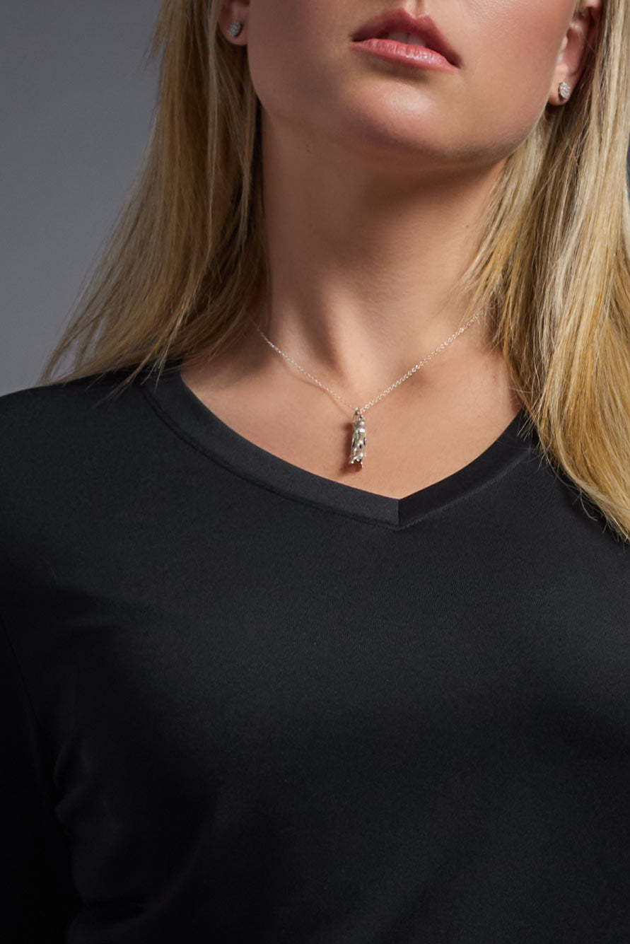 A female model wearing the women's DriMax V-Neck Long Sleeve Expert Tee  in the color black, made out of 100% polyester, showing the relaxed fit from a close-up collar view. This shirt is quick-drying, moisture-wicking, with up to 30 UV protection and made in the USA. #black