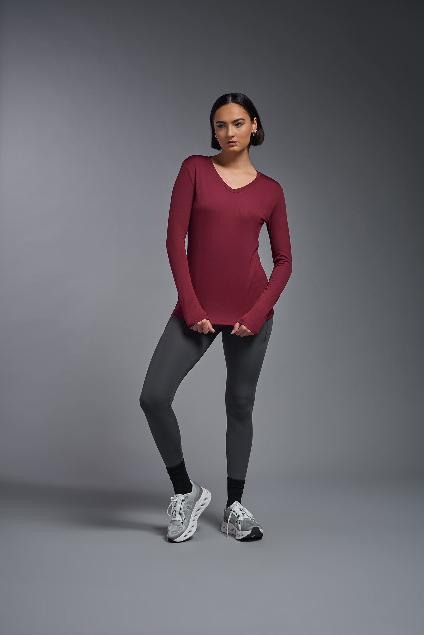 A female model wearing the women's DriMax V-Neck Long Sleeve Expert Tee  in the color cardinal, made out of 100% polyester, showing the relaxed fit from a front view. This shirt is quick-drying, moisture-wicking, with up to 30 UV protection and made in the USA. #cardinal