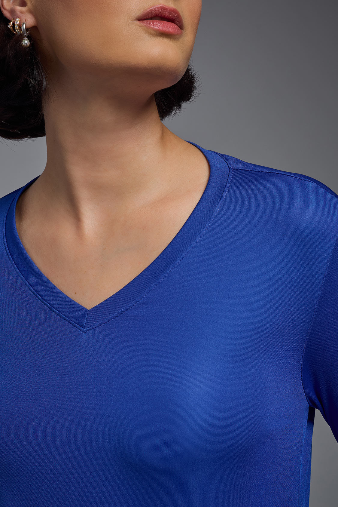 A female model wearing the women's DriMax V-Neck Long Sleeve Expert Tee  in the color royal blue, made out of 100% polyester, showing the relaxed fit from a close-up collar view. This shirt is quick-drying, moisture-wicking, with up to 30 UV protection and made in the USA. #royal