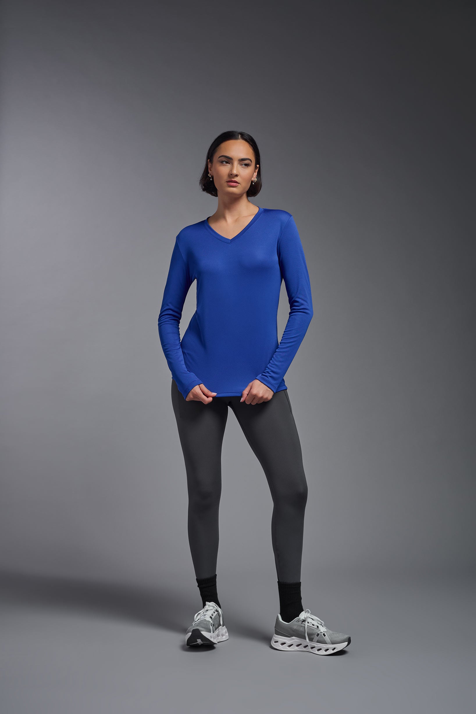 A female model wearing the women's DriMax V-Neck Long Sleeve Expert Tee  in the color royal blue, made out of 100% polyester, showing the relaxed fit from a front view. This shirt is quick-drying, moisture-wicking, with up to 30 UV protection and made in the USA. #royal