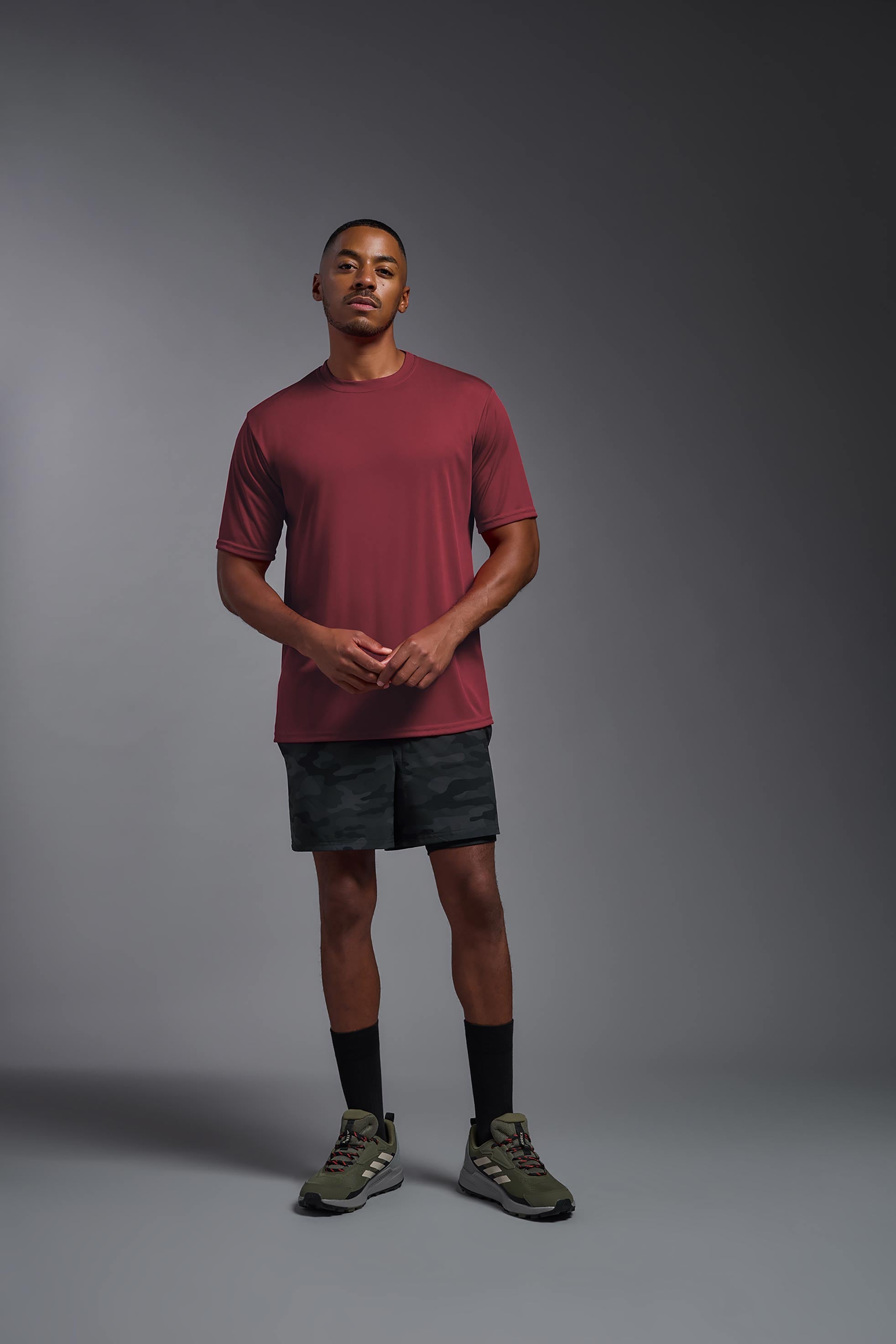 A male model wearing the men's DriMax Expert Tee in the color cardinal, made out of 100% polyester, showing the relaxed fit from a front view. #cardinal