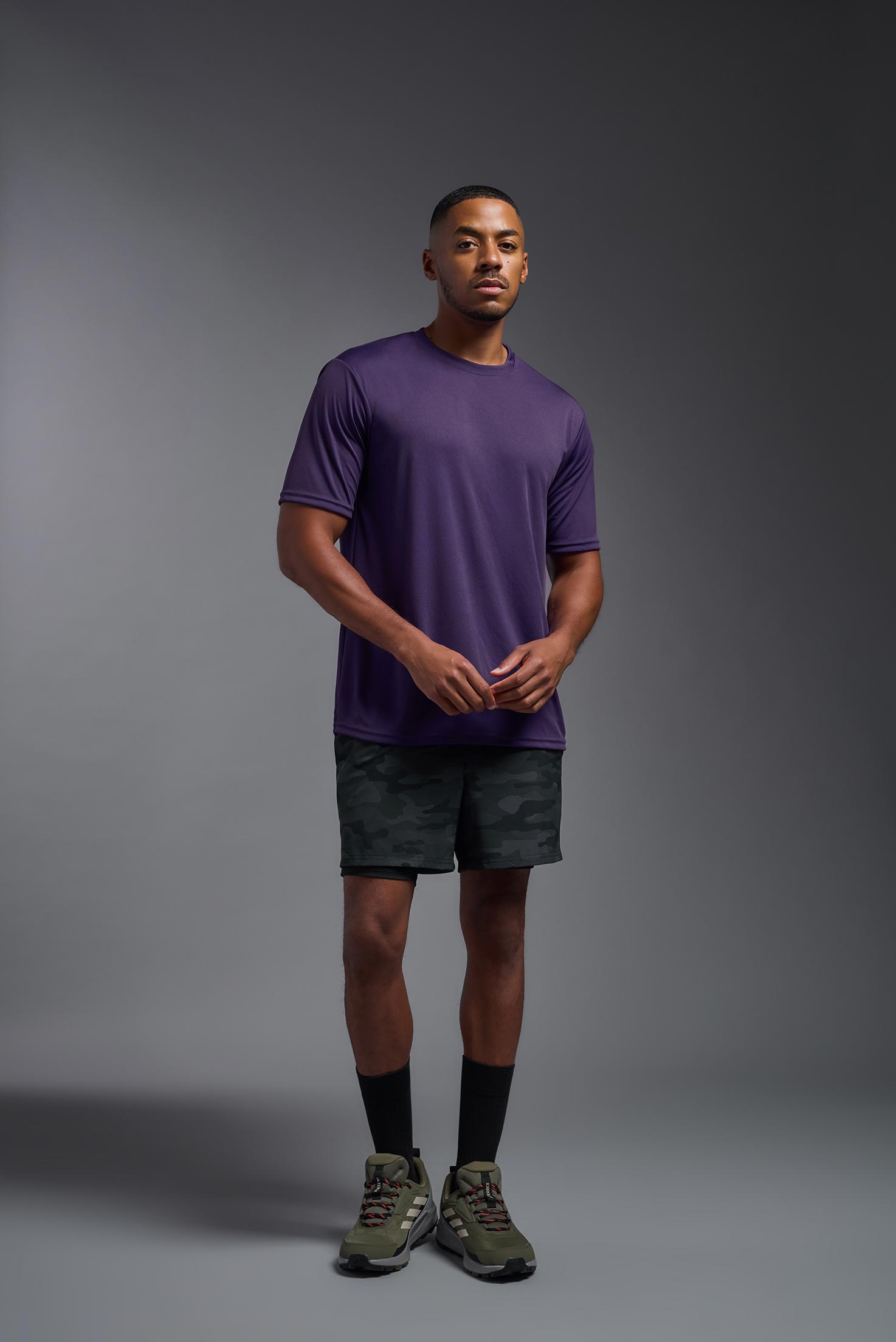 A male model wearing the men's DriMax Expert Tee in dark purple, made out of 100% polyester, showing the relaxed fit from a front view. #deep-purple