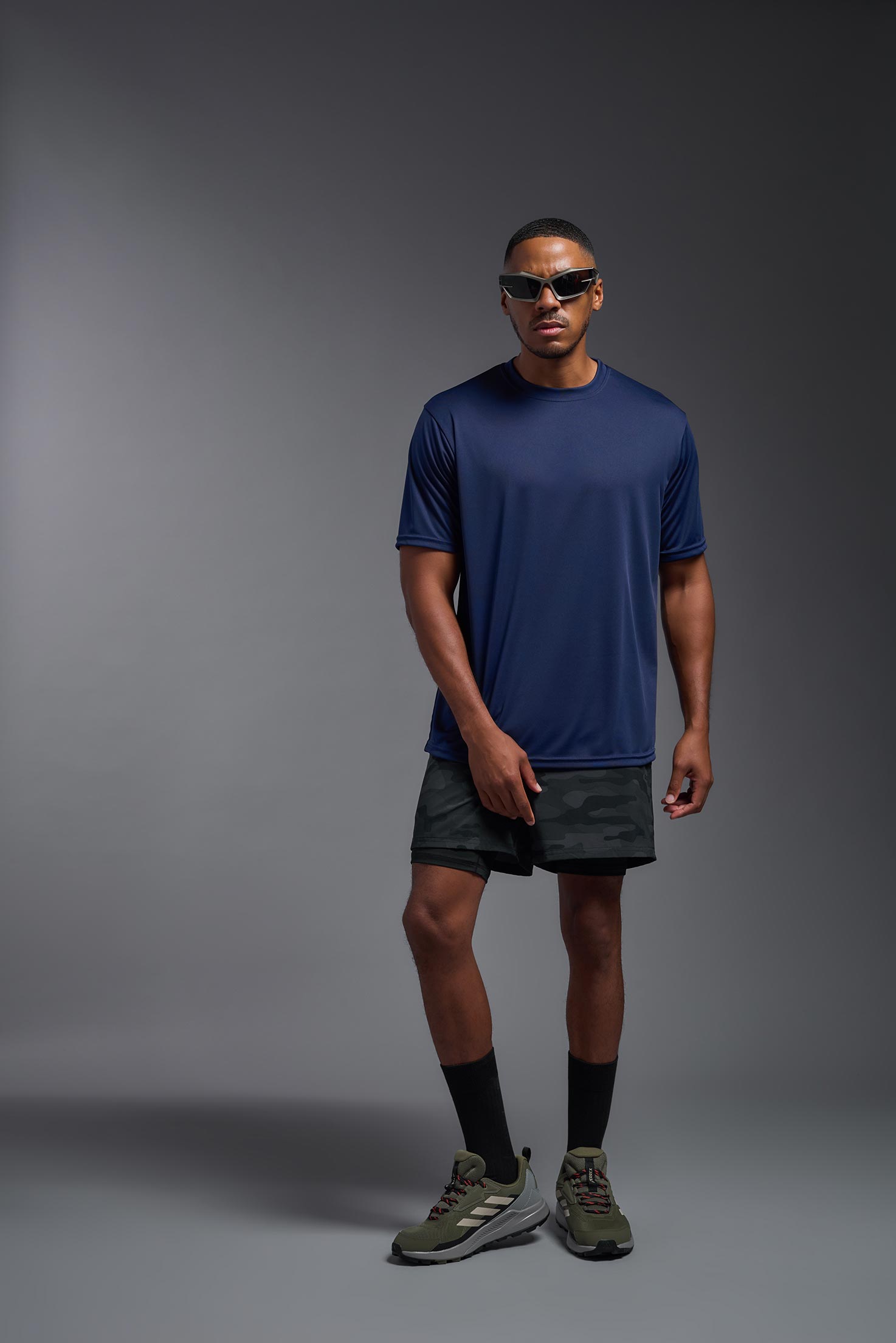 A male model wearing the men's DriMax Expert Tee in the color navy, made out of 100% polyester, showing the relaxed fit from a front view. This shirt is moisture-wicking, quick-drying, and made in the USA. #navy