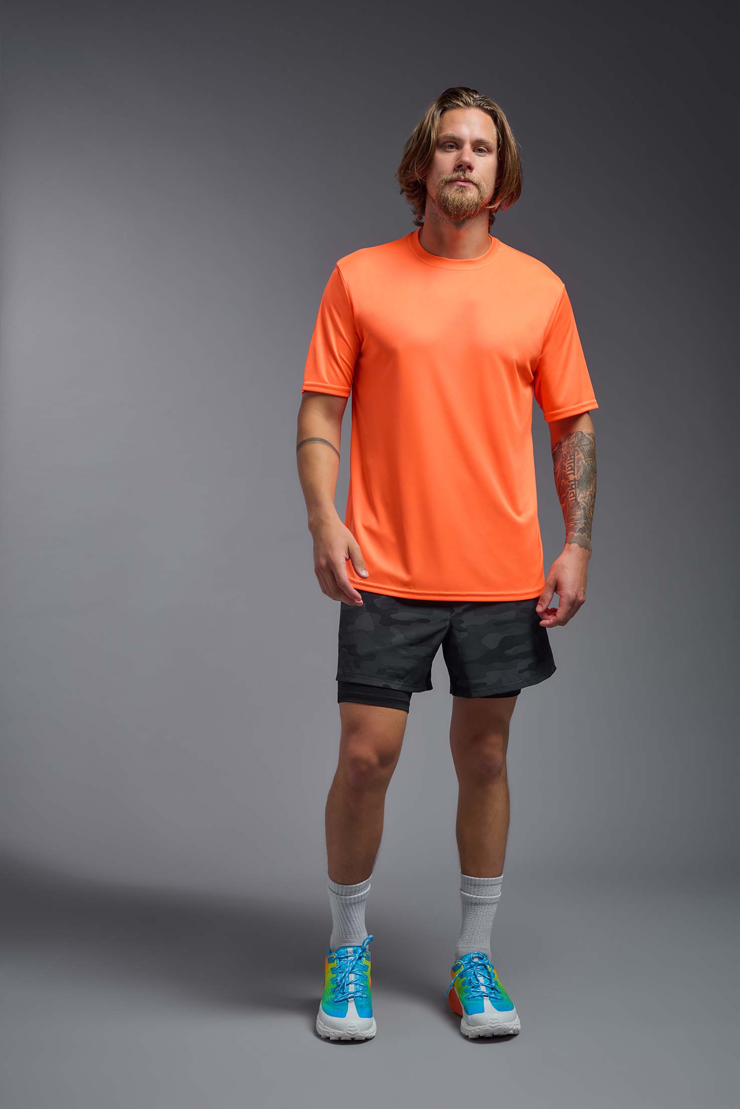 A male model wearing the men's DriMax Expert Tee in safety orange, made out of 100% polyester, showing the relaxed fit from a front view. #safety-orange