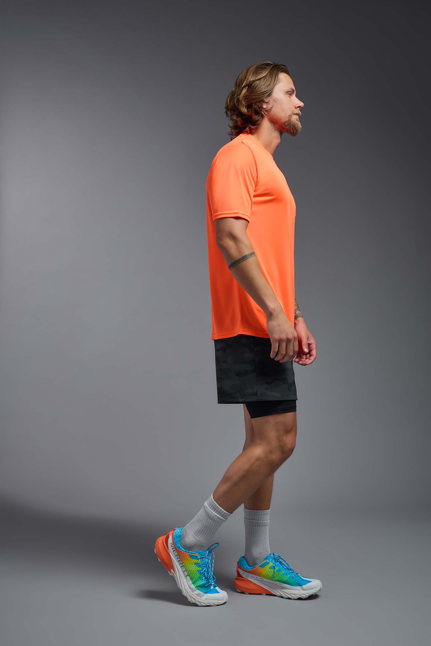 A male model wearing the men's DriMax Expert Tee in safety orange, made out of 100% polyester, showing the relaxed fit from a side view. #safety-orange
