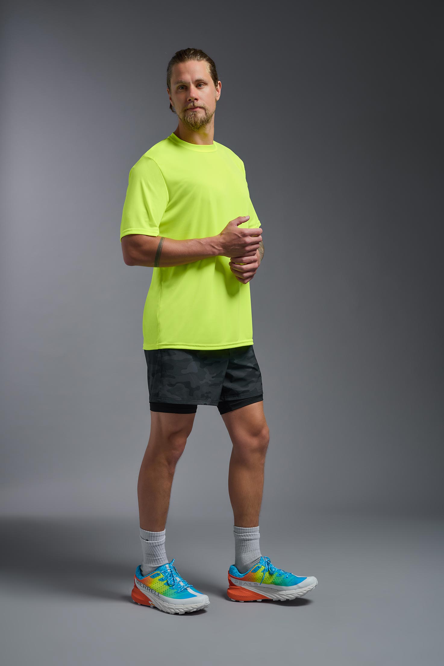 A male model wearing the men's DriMax Expert Tee in safety yellow, made out of 100% polyester, showing the relaxed fit from a side view. #safety-yellow