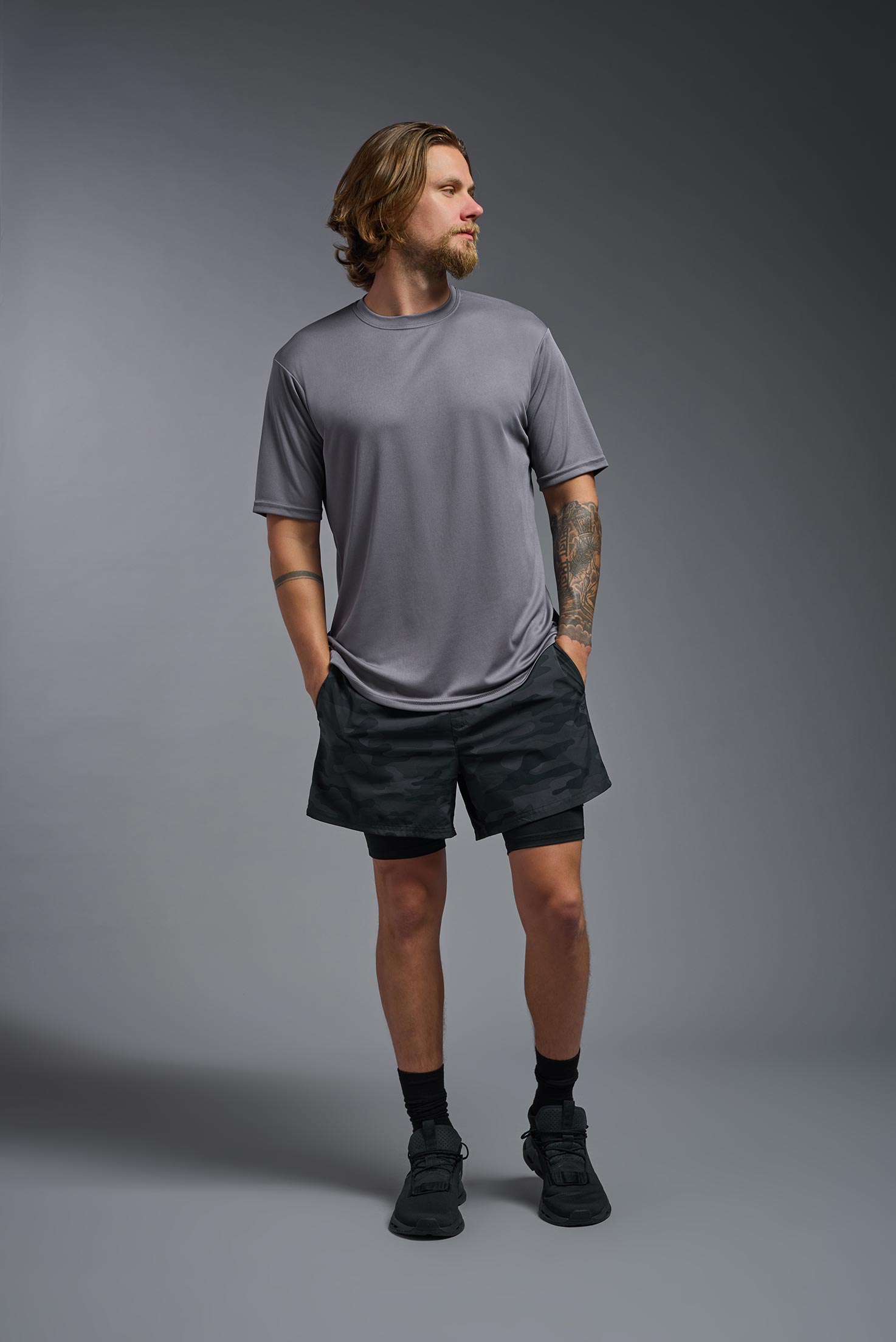 A male model wearing the men's DriMax Expert Tee in steel gray, made out of 100% polyester, showing the relaxed fit from a front view. This shirt is moisture-wicking, quick-drying, and made in the USA. #steel