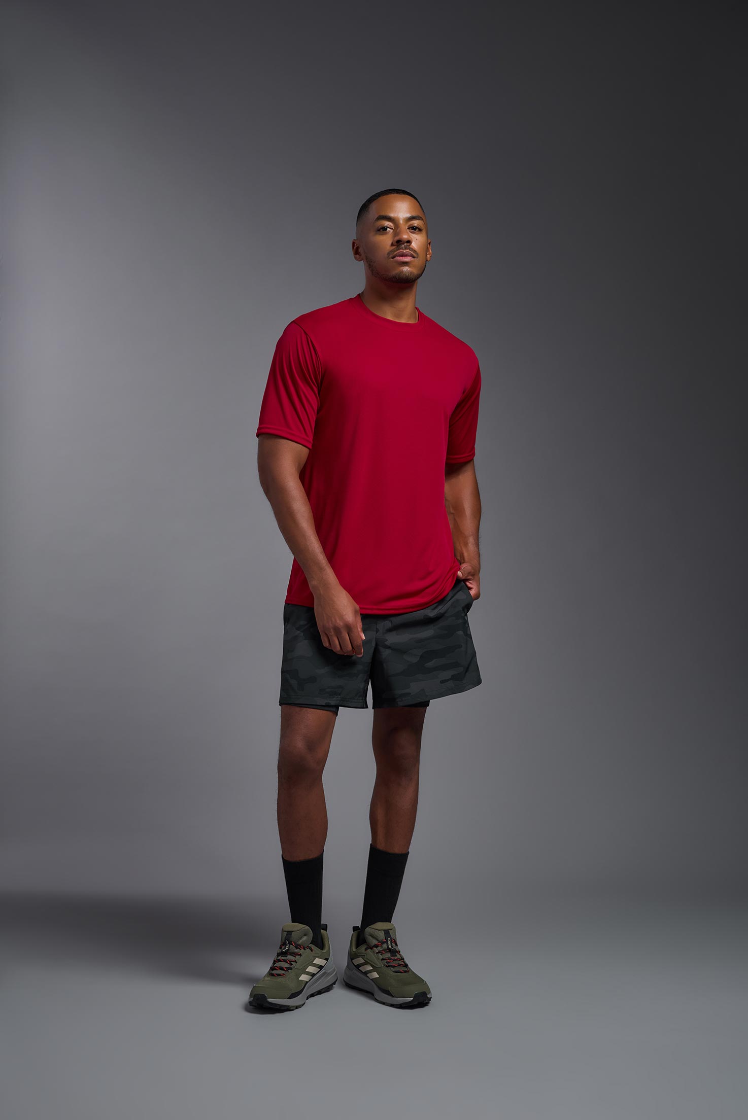 A male model wearing the men's DriMax Expert Tee in the color red, made out of 100% polyester, showing the relaxed fit from a front view. #red