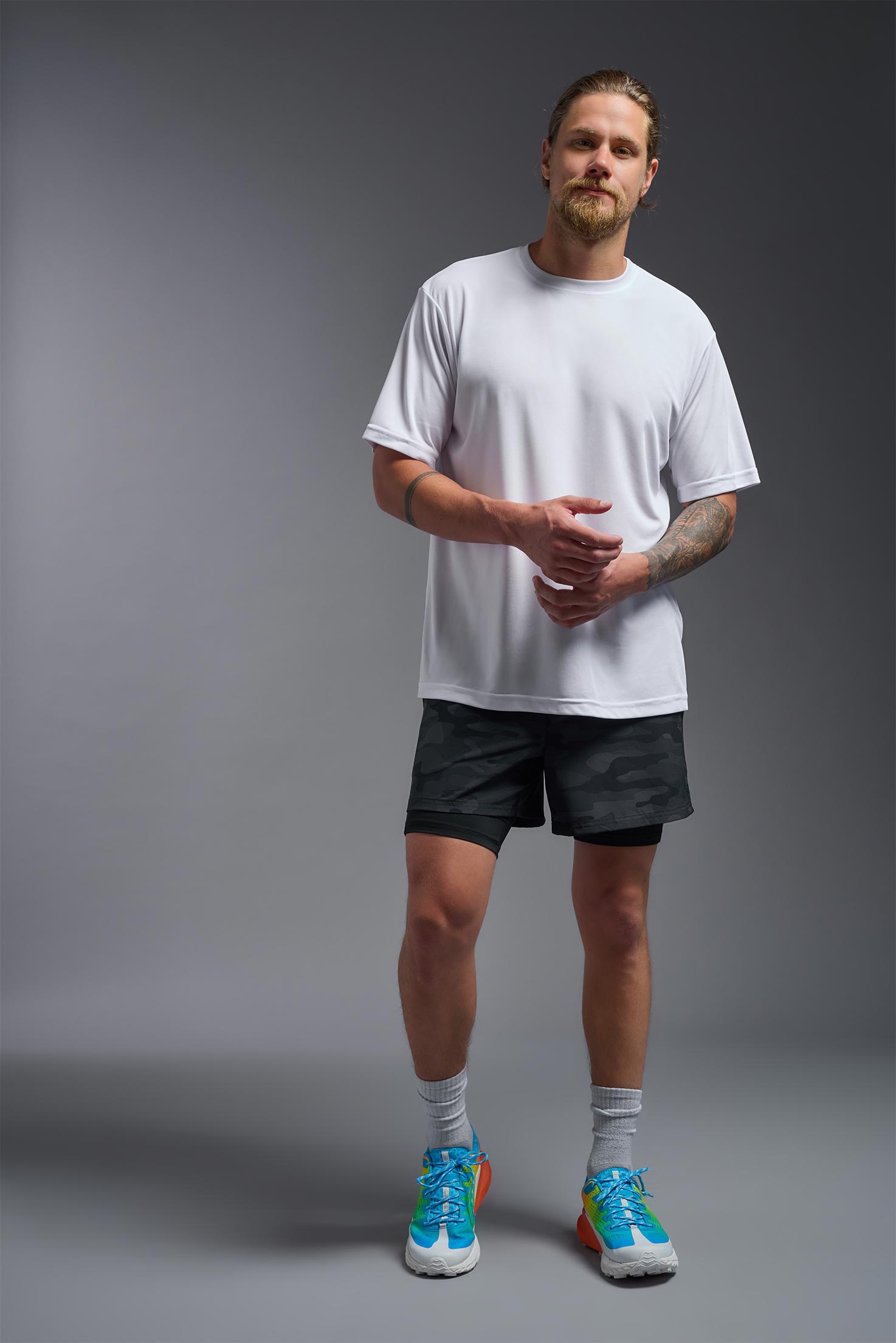A male model wearing the men's DriMax Expert Tee in the color white, made out of 100% polyester, showing the relaxed fit from a front view. #white