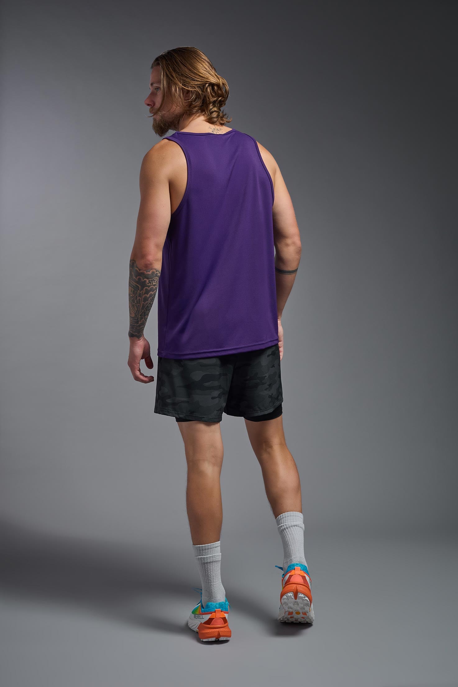A male model wearing the men's DriMax Endurance Tank in the color deep purple, made out of 100% polyester, showing the relaxed fit from a back view. #deep-purple