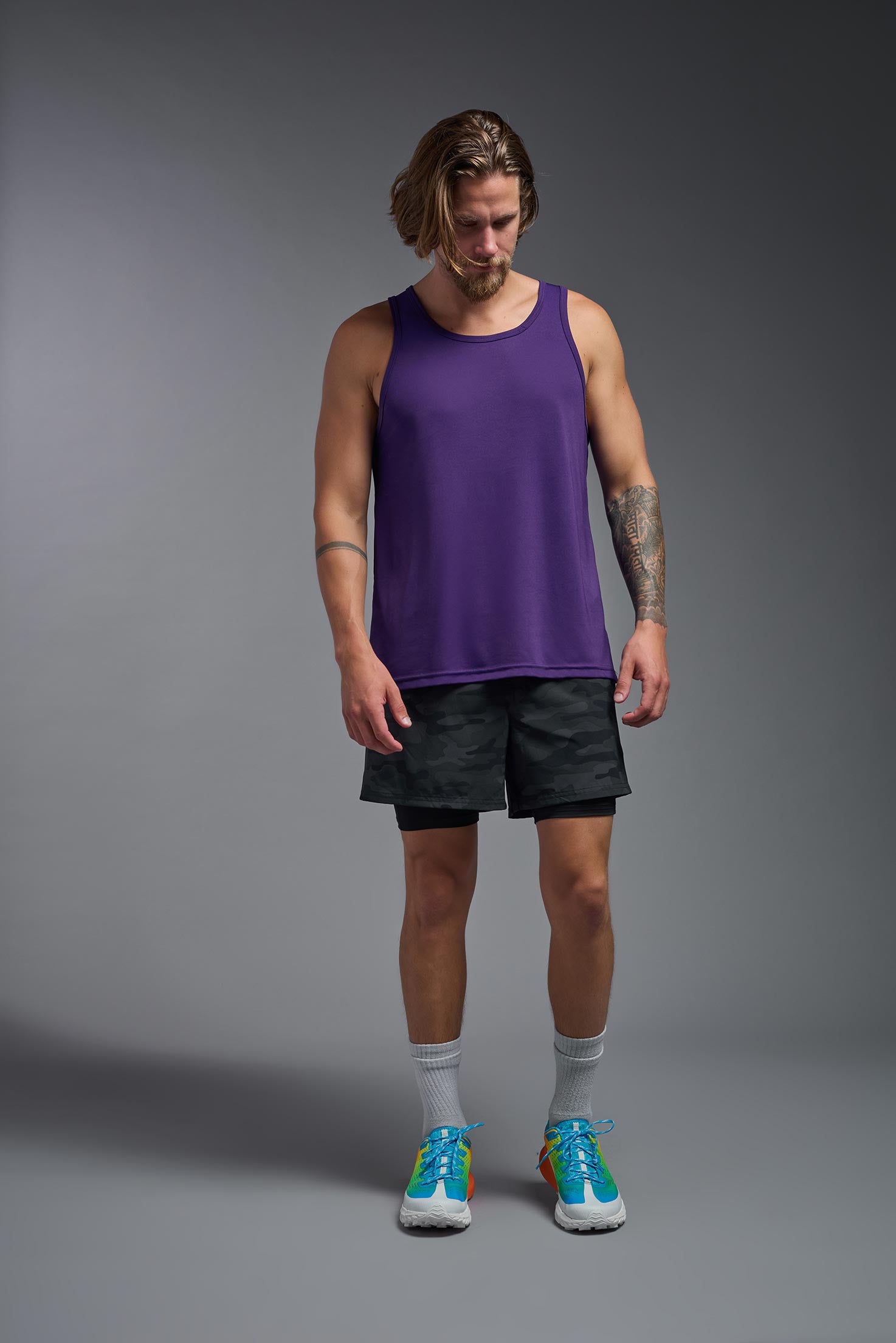 A male model wearing the men's DriMax Endurance Tank in the color deep purple, made out of 100% polyester, showing the relaxed fit from a front view. #deep-purple
