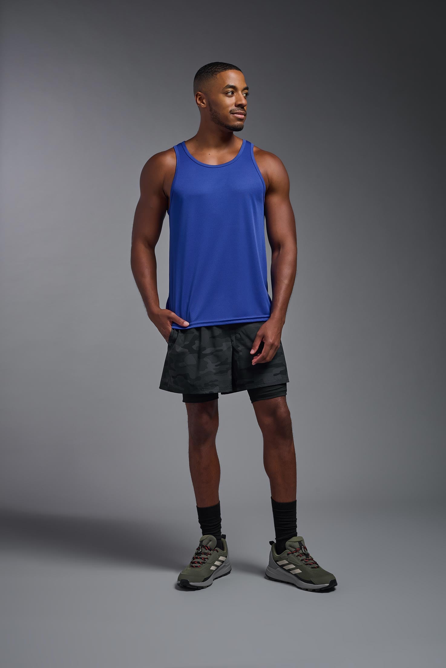 A male model wearing the men's DriMax Endurance Tank in the color royal blue, made out of 100% polyester, showing the relaxed fit from a front view. #royal