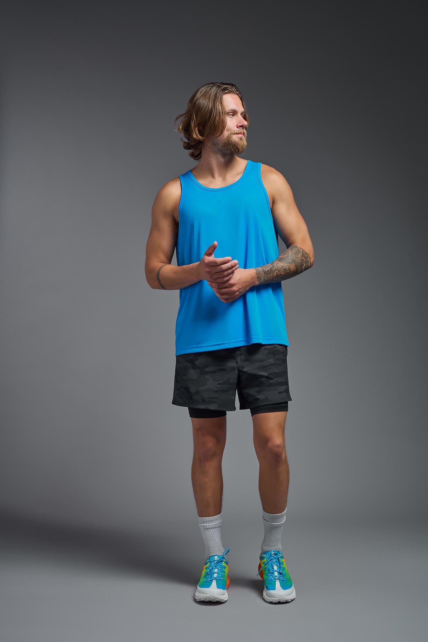 A male model wearing the men's DriMax Endurance Tank in the color safety blue, made out of 100% polyester, showing the relaxed fit from a front view. This tank is quick-drying and moisture-wicking and made in the USA #safety-blue