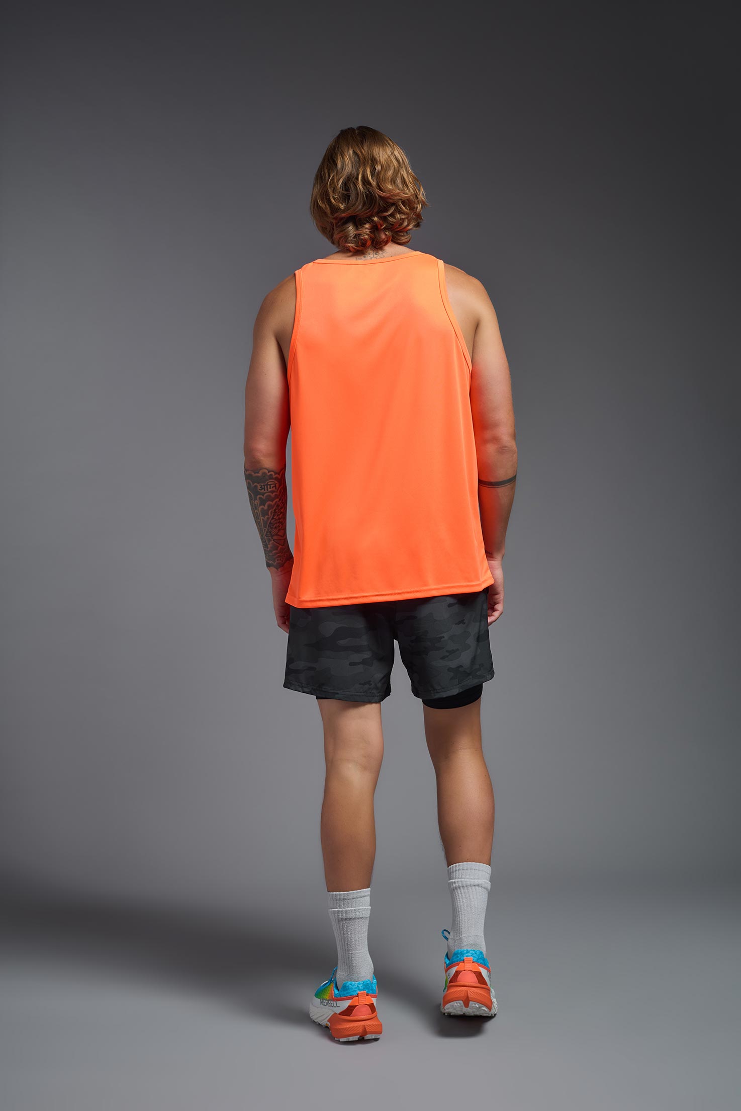 A male model wearing the men's DriMax Endurance Tank in the color safety orange, made out of 100% polyester, showing the relaxed fit from a back view. #safety-orange