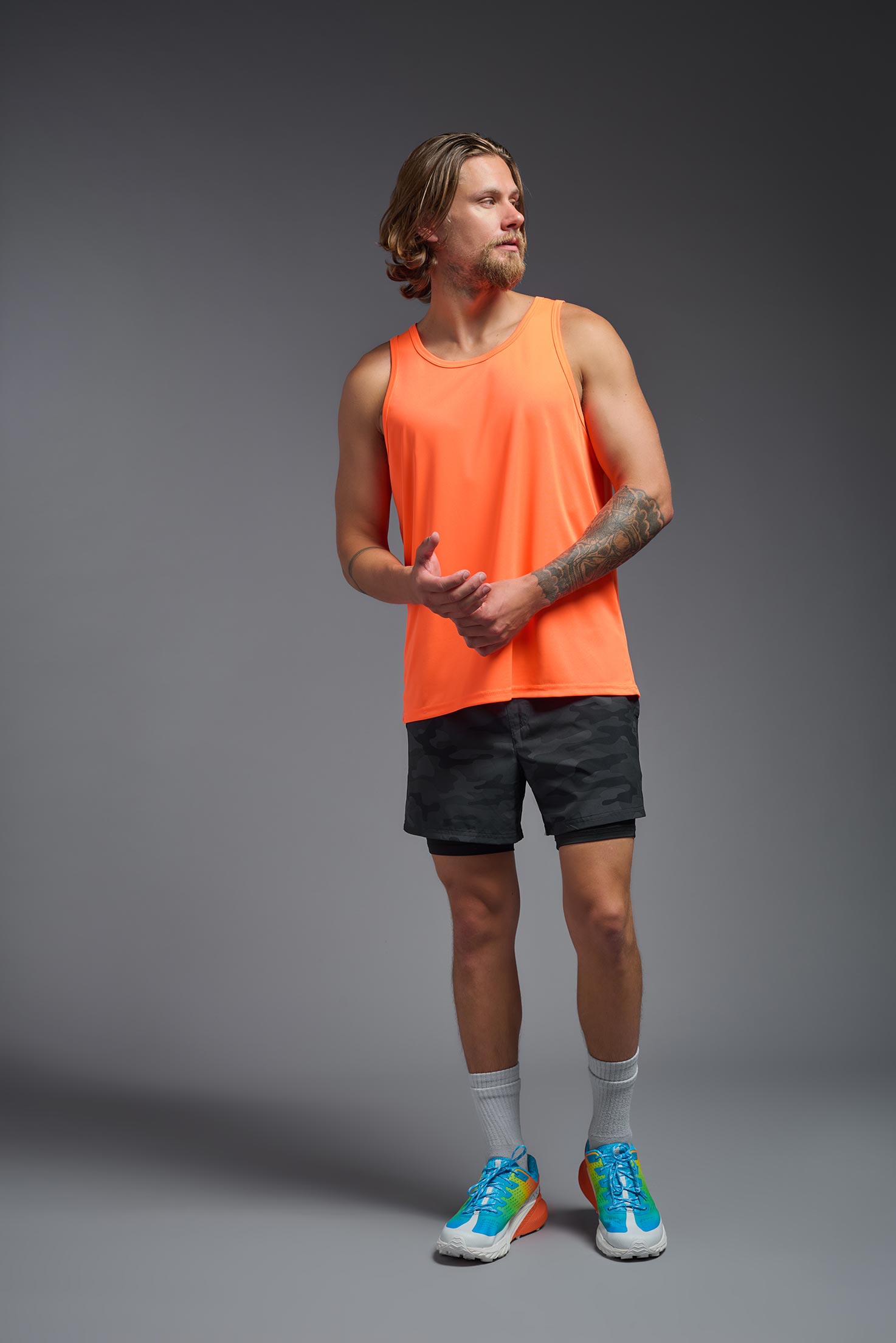 A male model wearing the men's DriMax Endurance Tank in the color safety orange, made out of 100% polyester, showing the relaxed fit from a front view. #safety-orange