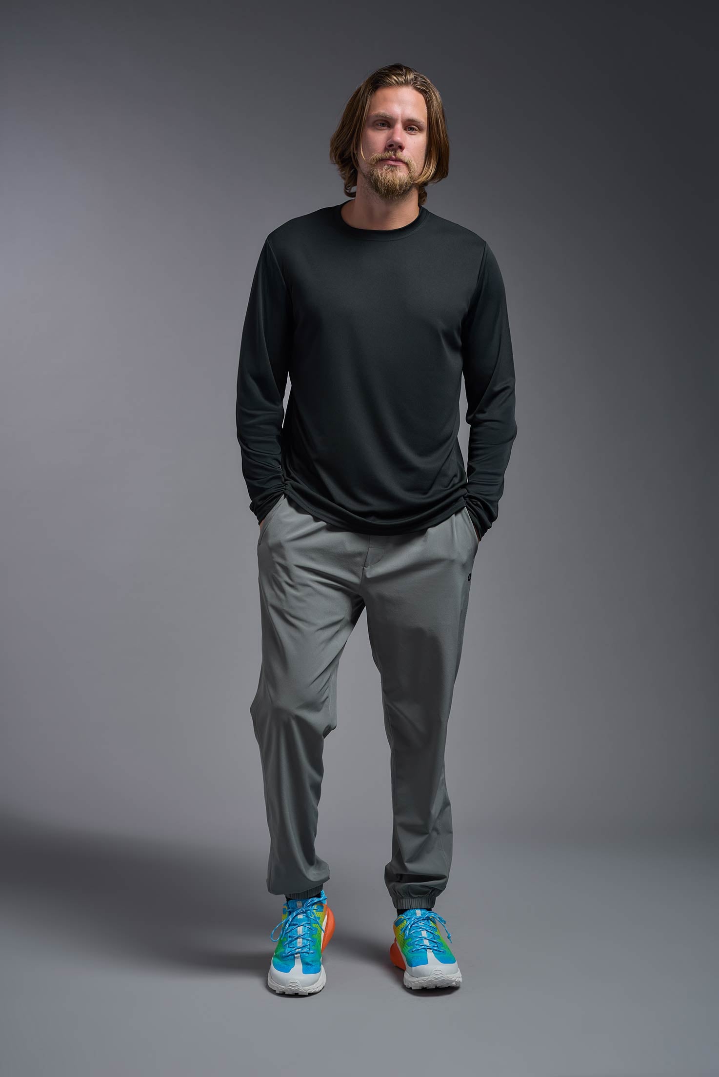 A male model wearing the men's DriMax Long Sleeve Expert Tee in black, made out of 100% polyester, showing the relaxed fit from a front view. #black