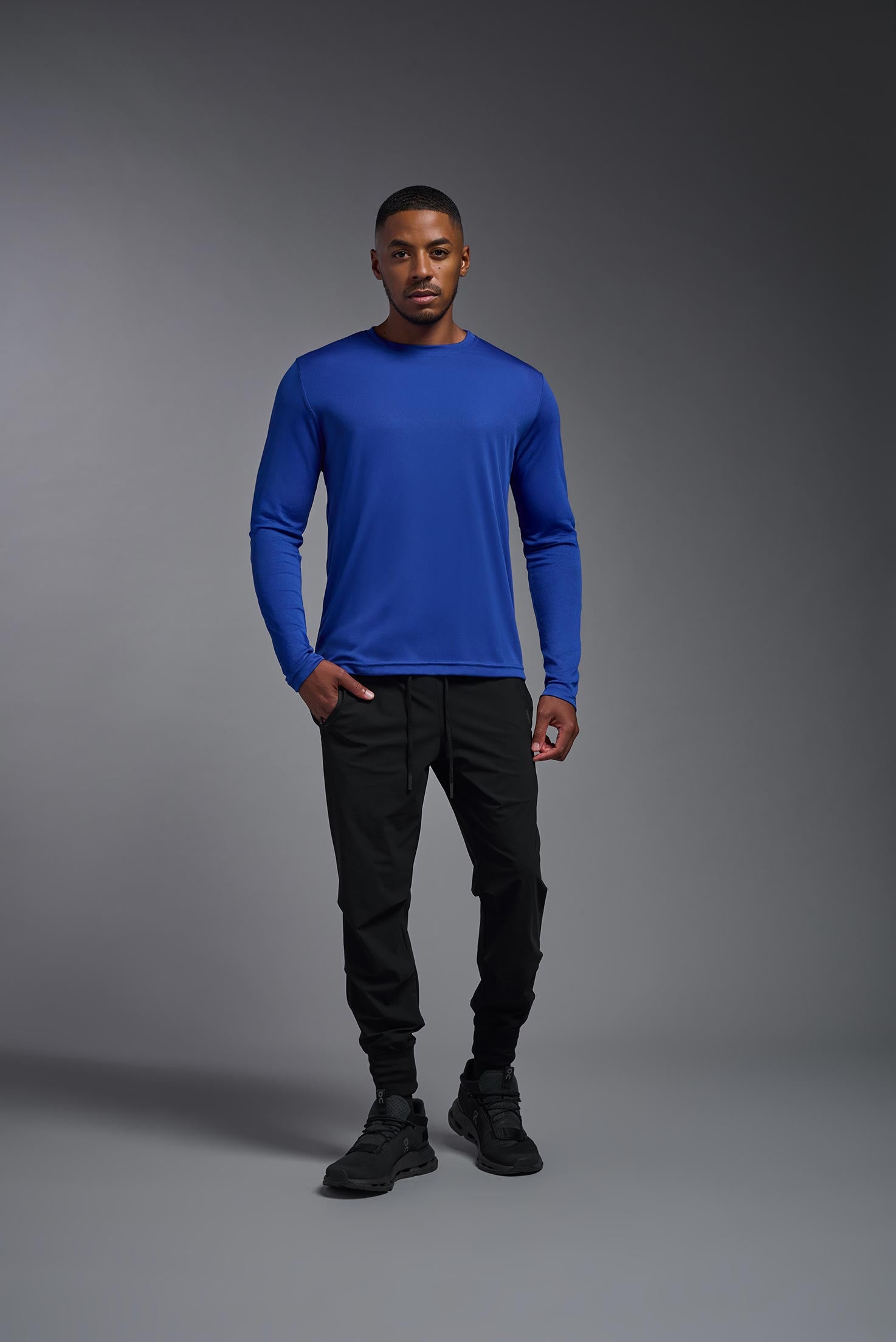 A male model wearing the men's DriMax Long Sleeve Expert Tee in the color royal blue, made out of 100% polyester, showing the relaxed fit from a front iew. #royal