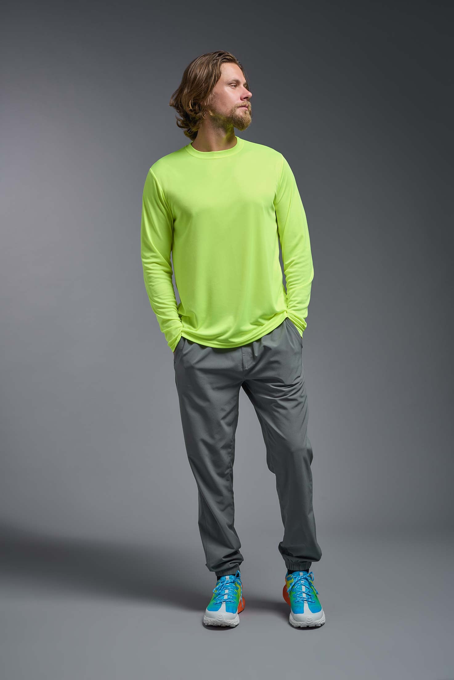 A male model wearing the men's DriMax Long Sleeve Expert Tee in safety yellow, made out of 100% polyester, showing the relaxed fit from a front view. #safety-yellow