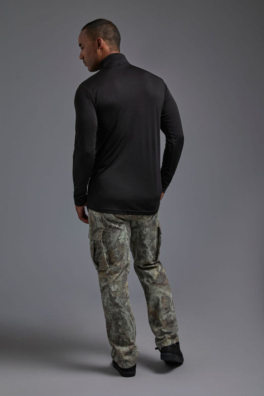 A male model wearing the men's DriMax Quarterzip Training Top in the color black, made out of 100% polyester, showing the relaxed fit from a back view. This Quarter Zip is made in the USA wicks sweat, quick dries like drifit, and controls odors. #black