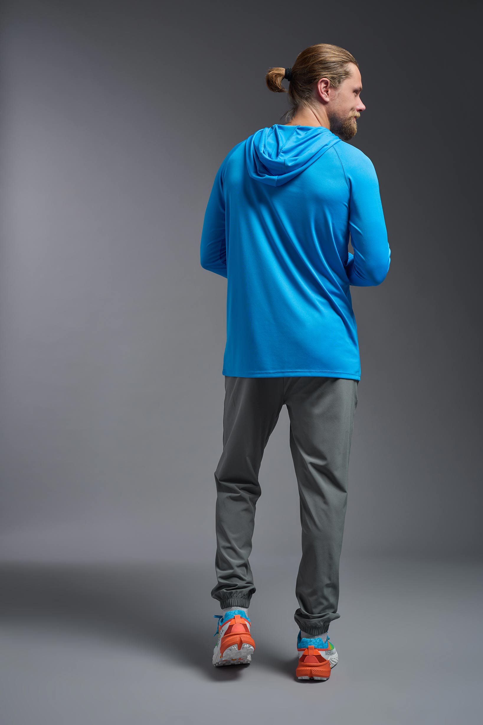 A male model wearing the men's DriMax Lightweight Hoodie in the color safety blue, made out of 100% polyester, showing the relaxed fit from a back view. #safety-blue