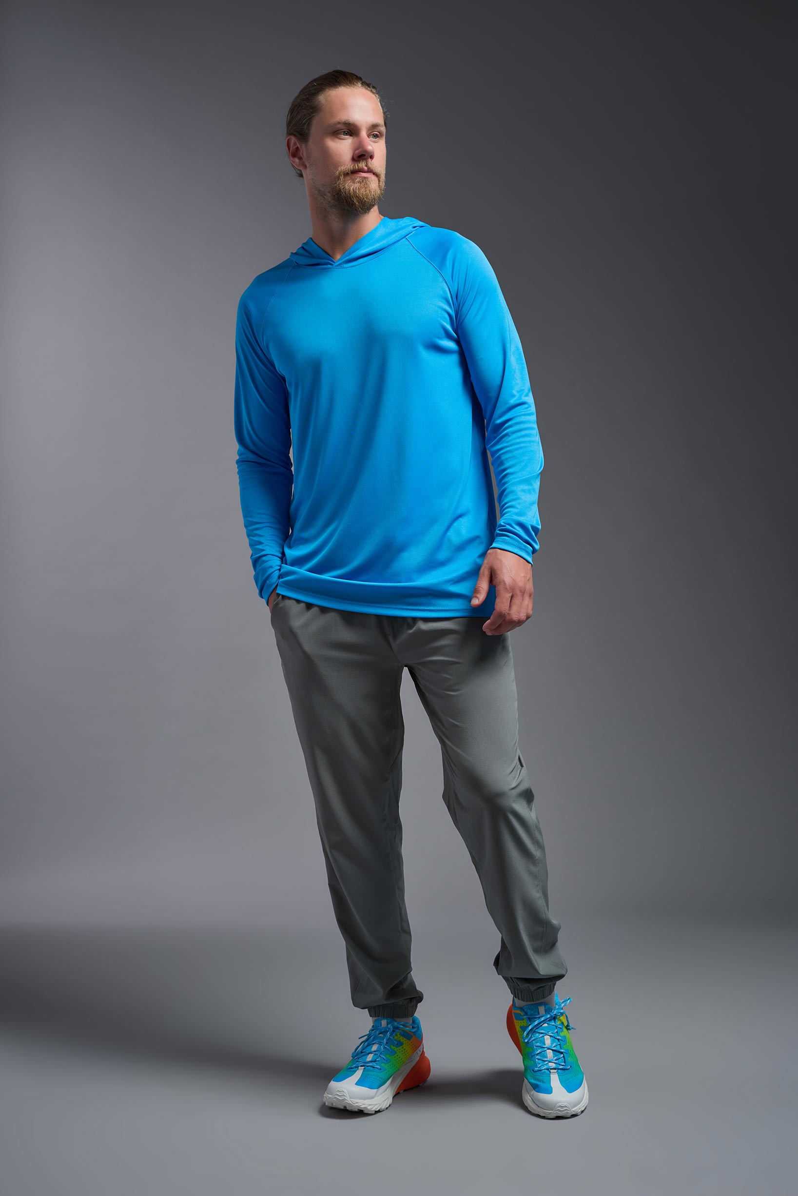 A male model wearing the men's DriMax Lightweight Hoodie in the color safety blue, made out of 100% polyester, showing the relaxed fit from a front view. #safety-blue
