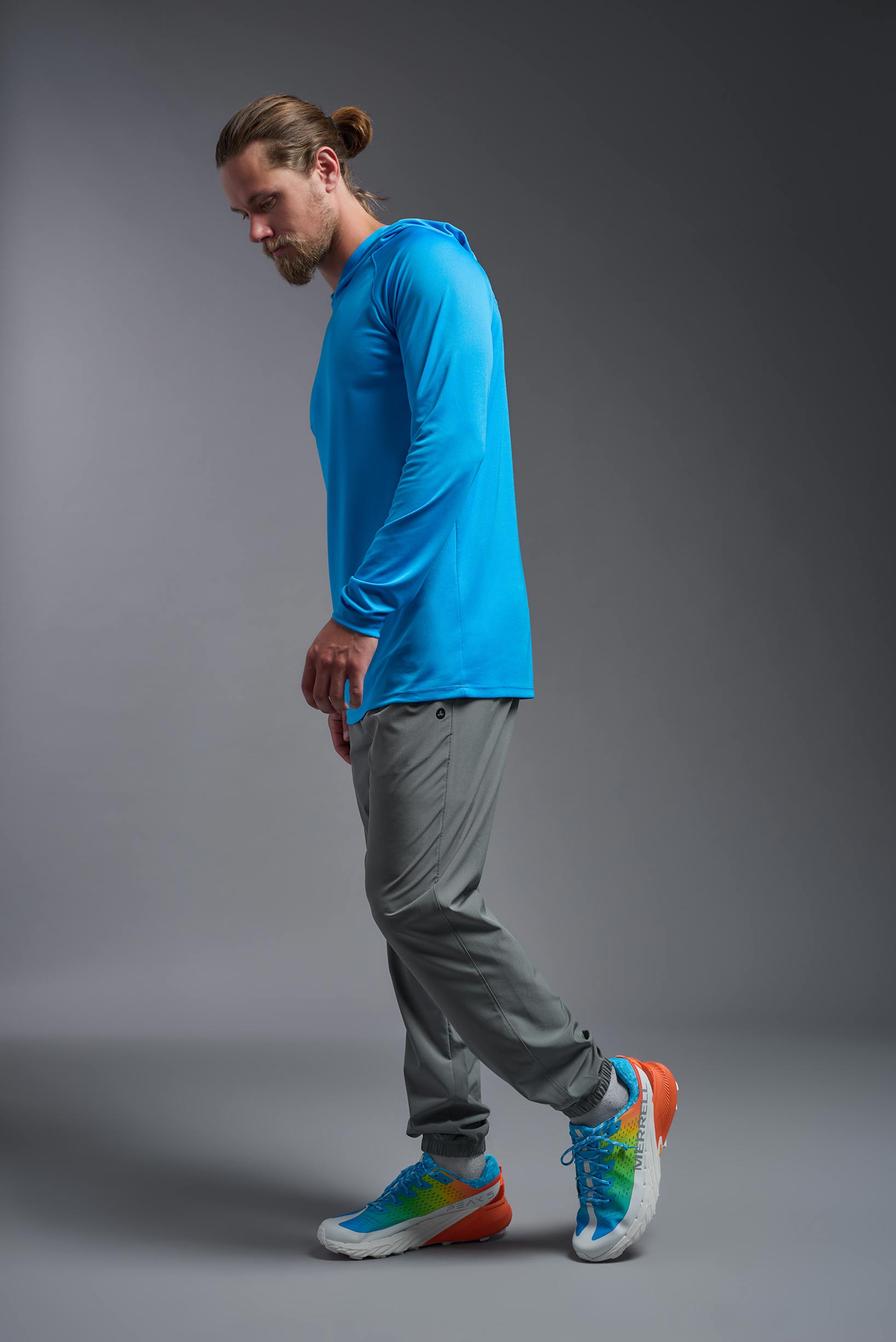 A male model wearing the men's DriMax Lightweight Hoodie in the color safety blue, made out of 100% polyester, showing the relaxed fit from a side view. #safety-blue