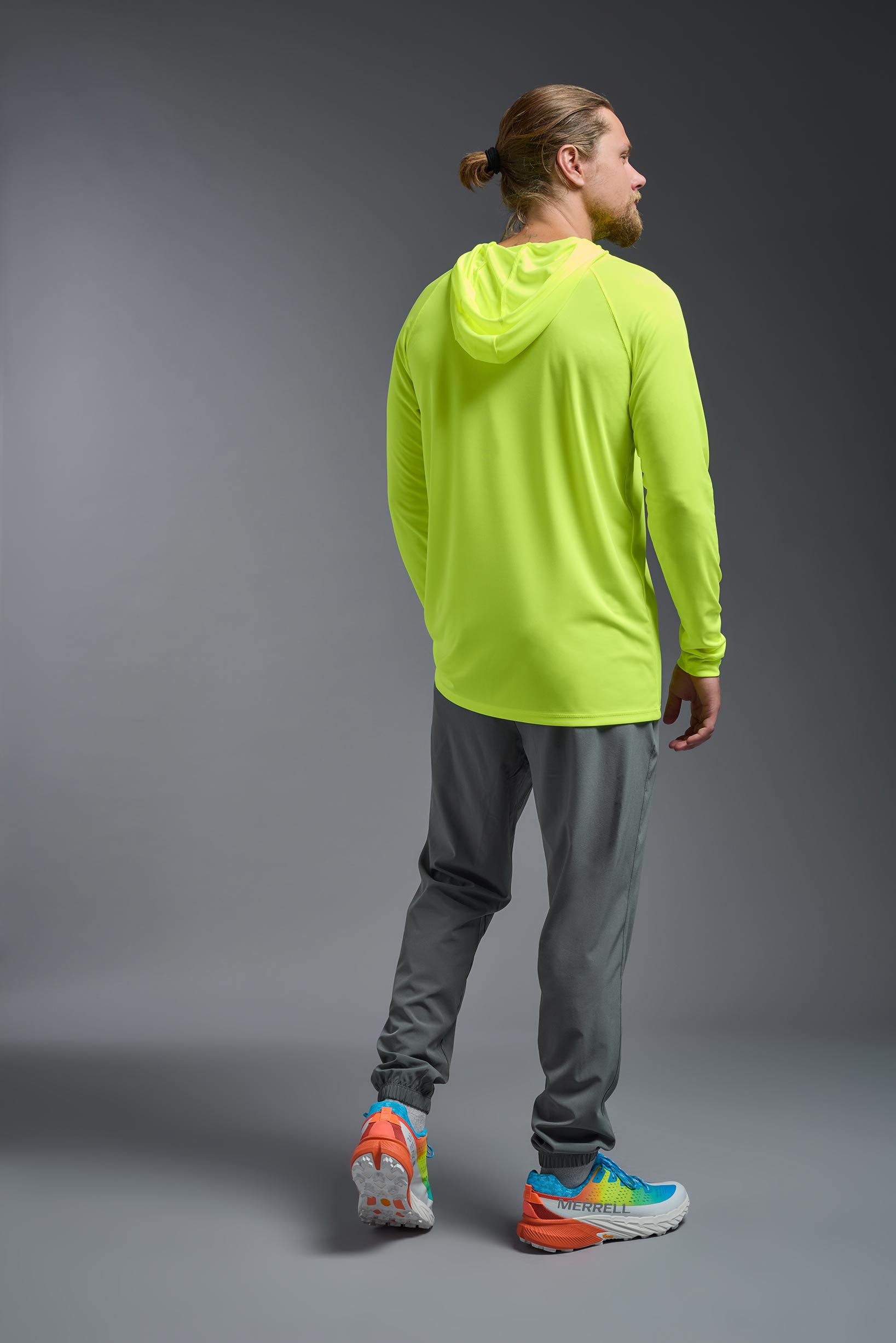 A male model wearing the men's DriMax Lightweight Hoodie in safety yellow, made out of 100% polyester, showing the relaxed fit from a back view. #safety-yellow