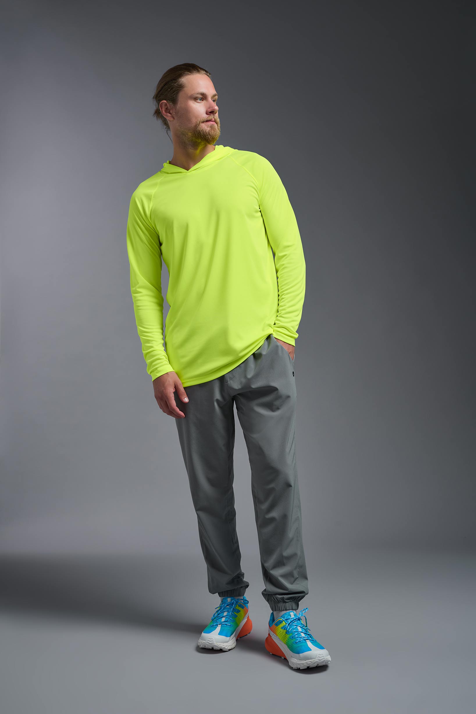 A male model wearing the men's DriMax Lightweight Hoodie in safety yellow, made out of 100% polyester, showing the relaxed fit from a front view. #safety-yellow