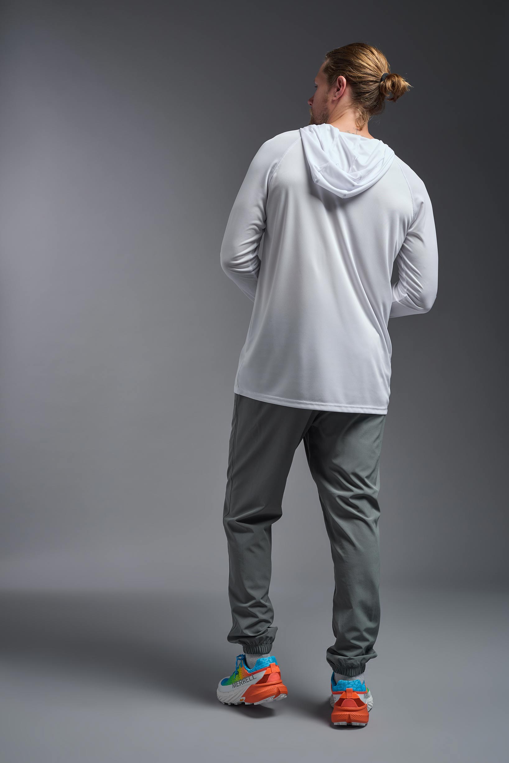 A male model wearing the men's DriMax Lightweight Hoodie in the color white, made out of 100% polyester, showing the relaxed fit from a back view. #white