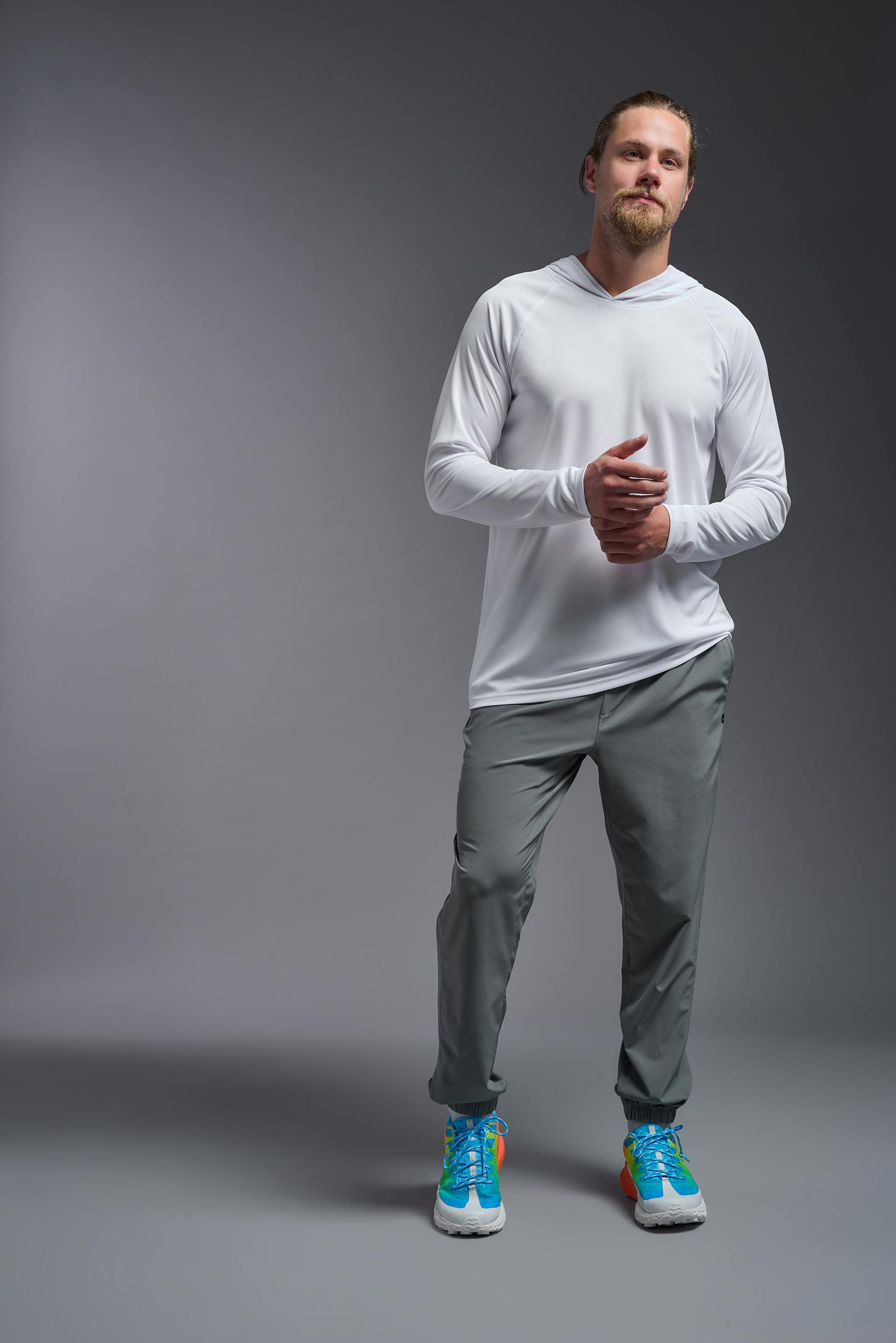 A male model wearing the men's DriMax Lightweight Hoodie in the color white, made out of 100% polyester, showing the relaxed fit from a front view. #white