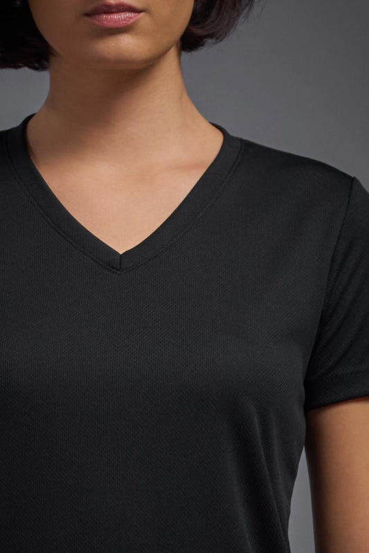 A female model wearing the women's Oxymesh V-neck Tech Tee in the color black, made out of 100% polyester, showing the relaxed fit from a close-up collar view. This shirt is breathable, wicks away moisture, quick-dries, and is made in the USA. #black