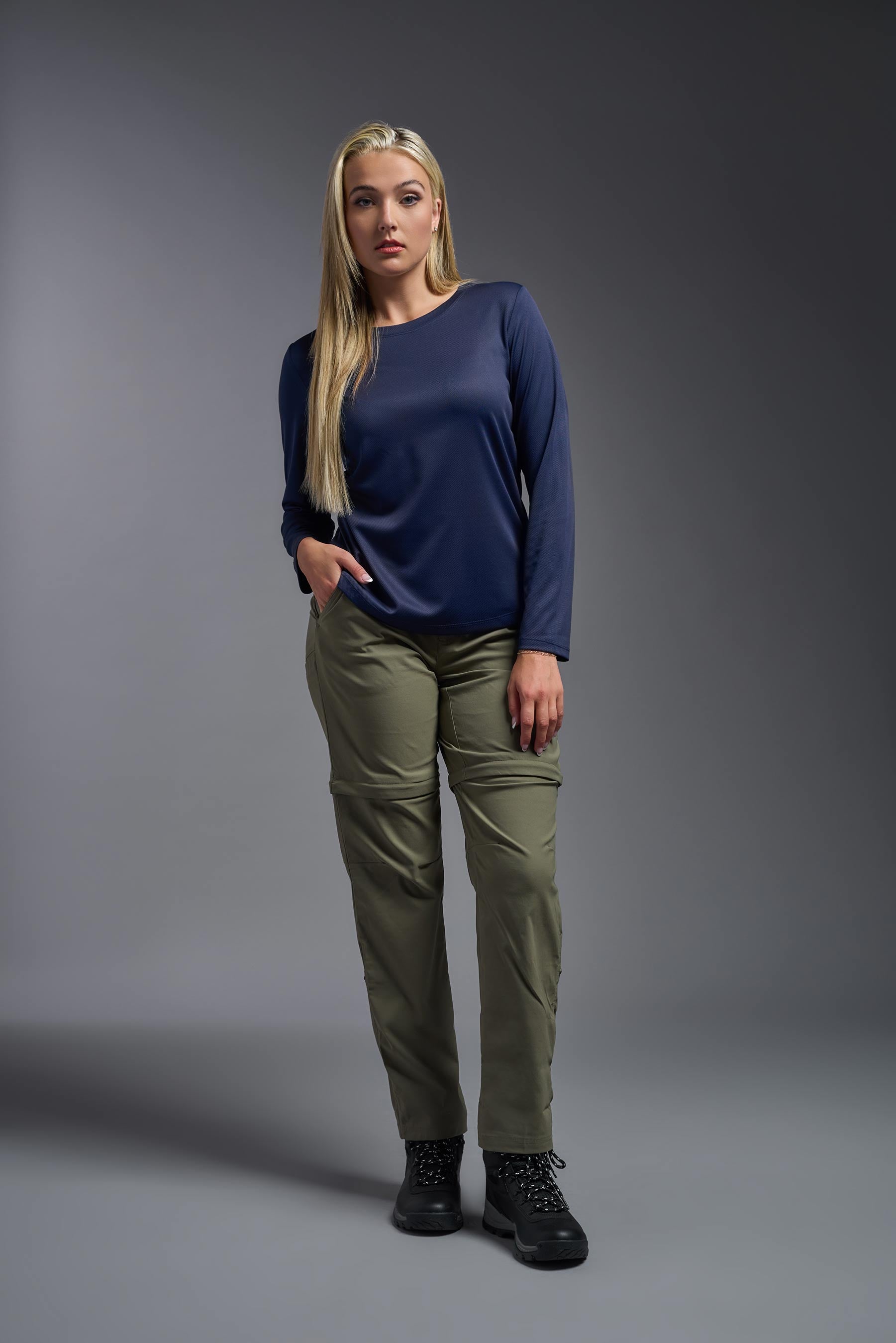 A female model wearing the women's Oxymesh Long Sleeve Tech Tee Imported Version in the color navy blue, made out of 100% polyester, showing the relaxed fit from a front view. This shirt is breathable, quick-drying, moisture-wicking, and Imported for a better price on bulk apparel. #navy-blue