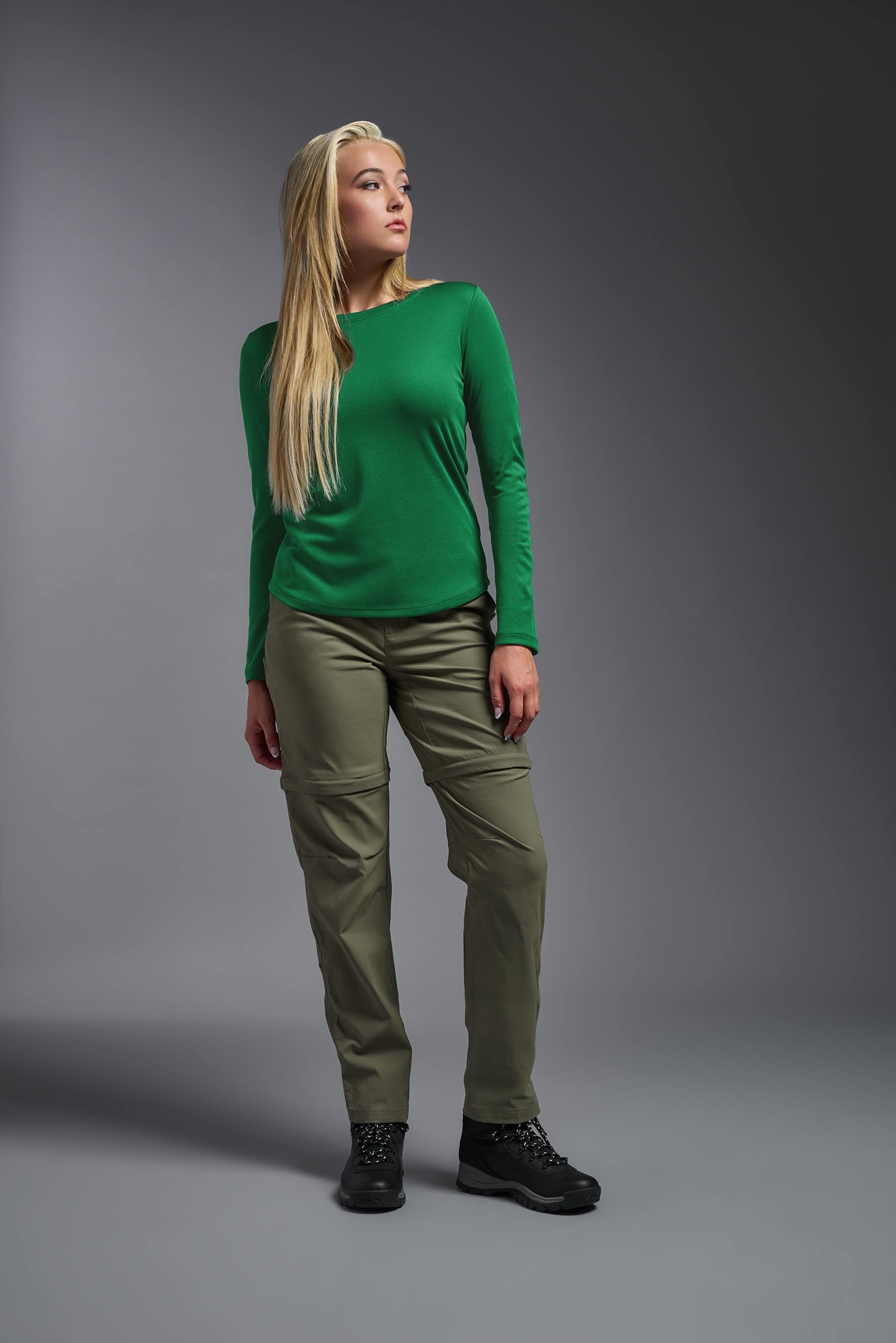 A female model wearing the women's Oxymesh Long Sleeve Tech Tee in the color kelly green, made out of 100% polyester, showing the relaxed fit from a front view. This shirt is breathable, quick-drying, moisture-wicking, and made in the USA. #kelly-green