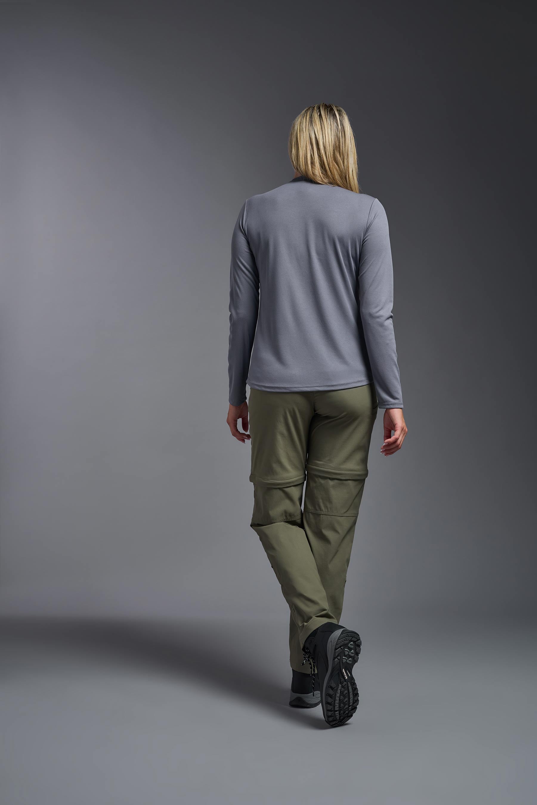 A female model wearing the women's Oxymesh Long Sleeve Tech Tee in the color steel gray, made out of 100% polyester, showing the relaxed fit from a front view. This shirt is breathable, quick-drying, moisture-wicking, and made in the USA. #steel-gray