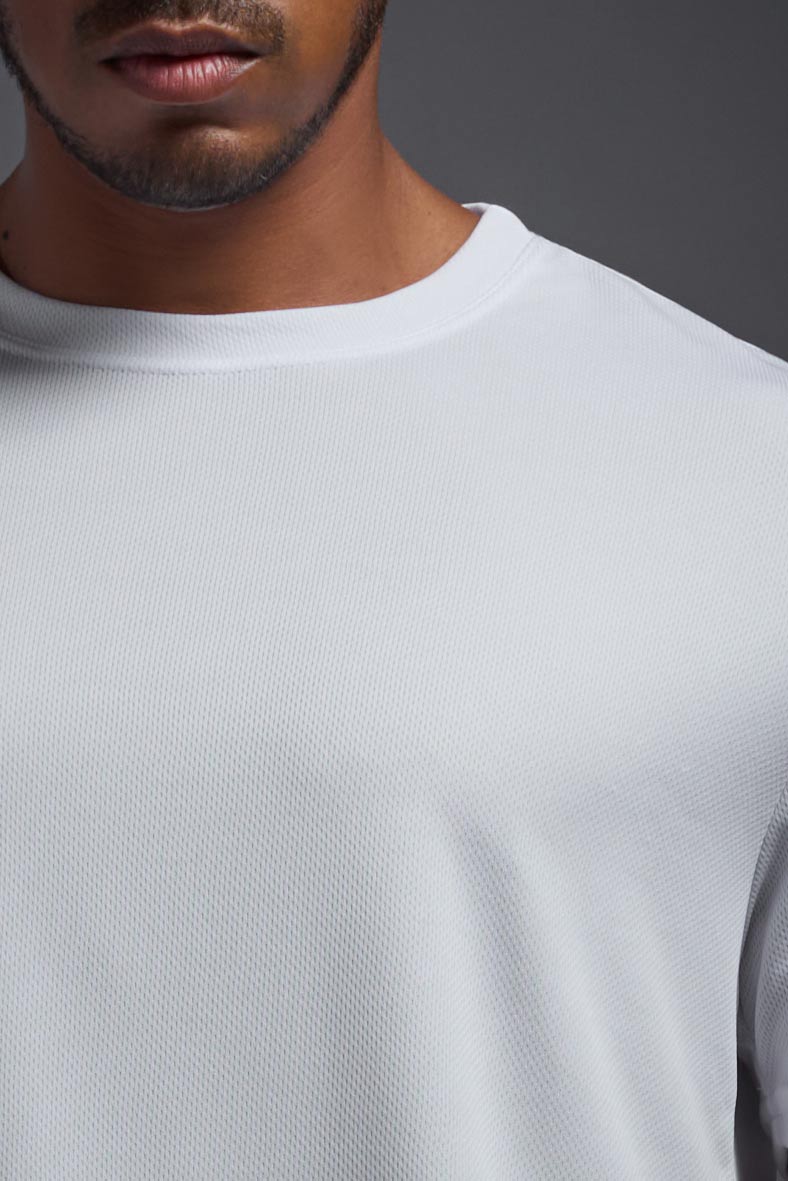 A male model wearing the men's Oxymesh Crewneck Tech Tee Imported Version in the color white, made out of 100% polyester, showing the relaxed fit from a close-up collar view. This shirt is breathable, quick-drying, moisture-wicking, and Imported for a better price on bulk apparel. #white