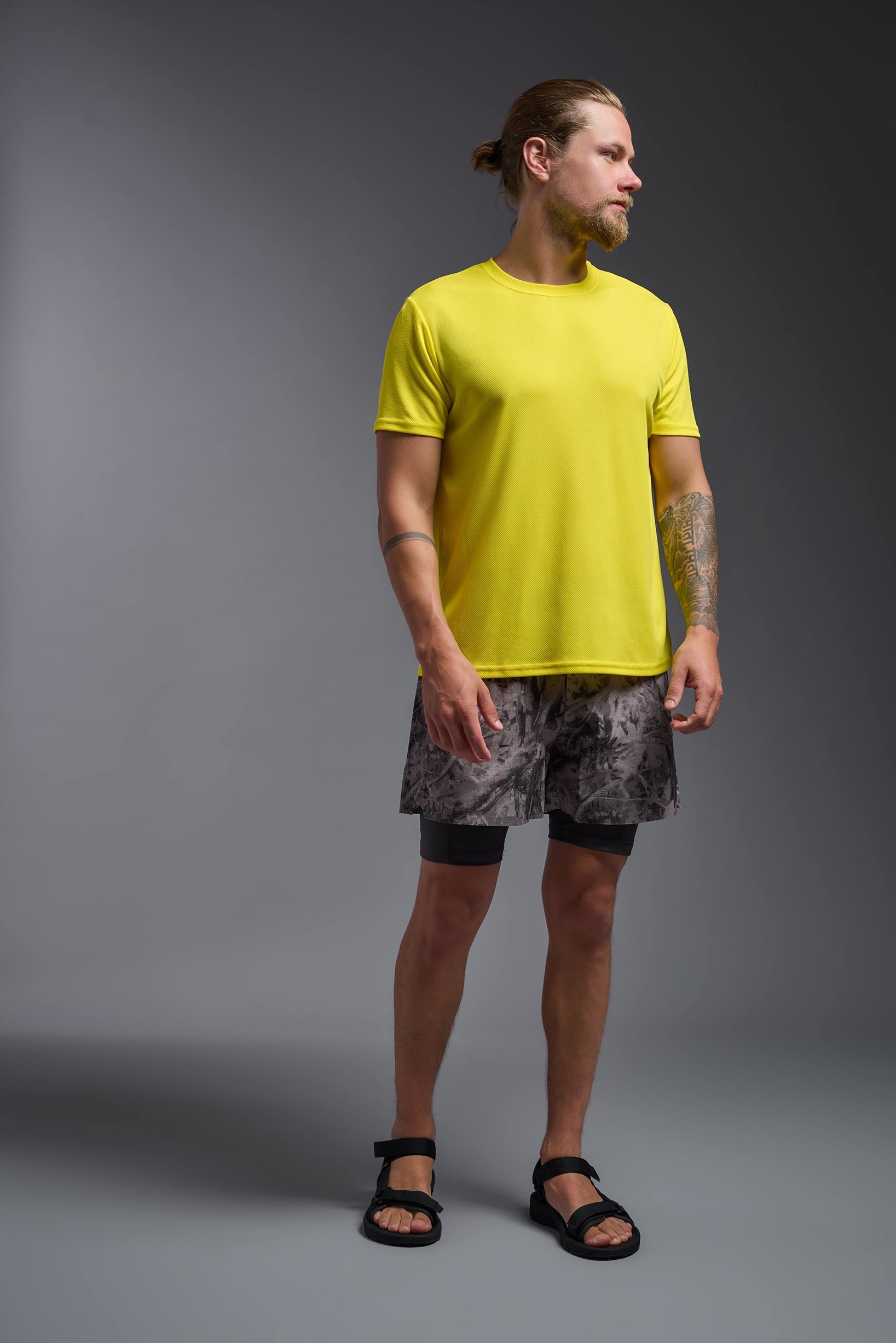 A male model wearing the men's Oxymesh Crewneck Tech Tee in the color bright yellow, made out of 100% polyester, showing the relaxed fit from a front view. This shirt is breathable, wicks away moisture, quick-dries, and is made in the USA. #bright-yellow