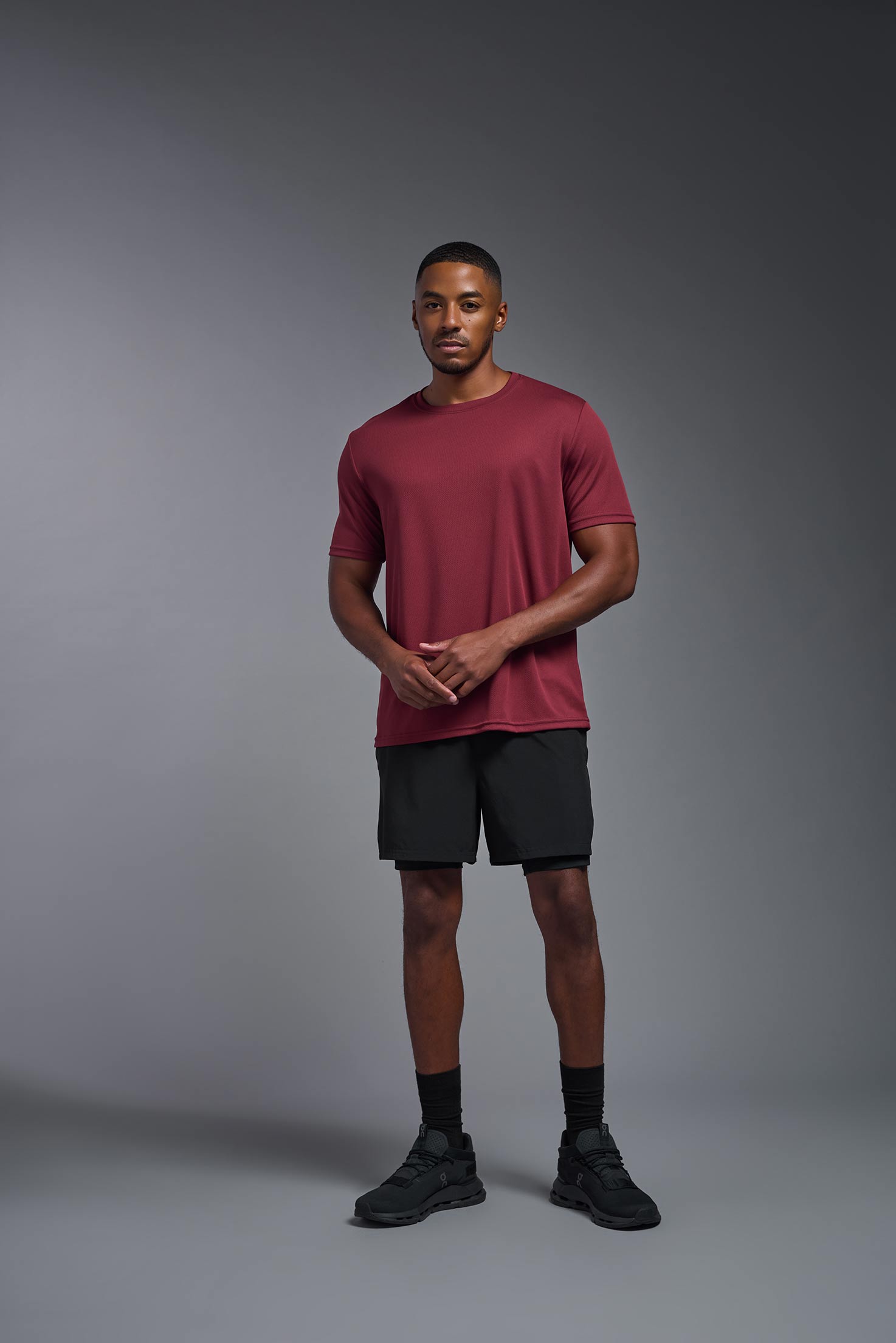A male model wearing the men's Oxymesh Crewneck Tech Tee in the color cardinal made out of 100% polyester, showing the relaxed fit from a front view. This shirt is breathable, wicks away moisture, quick-dries, and is made in the USA. #cardinal
