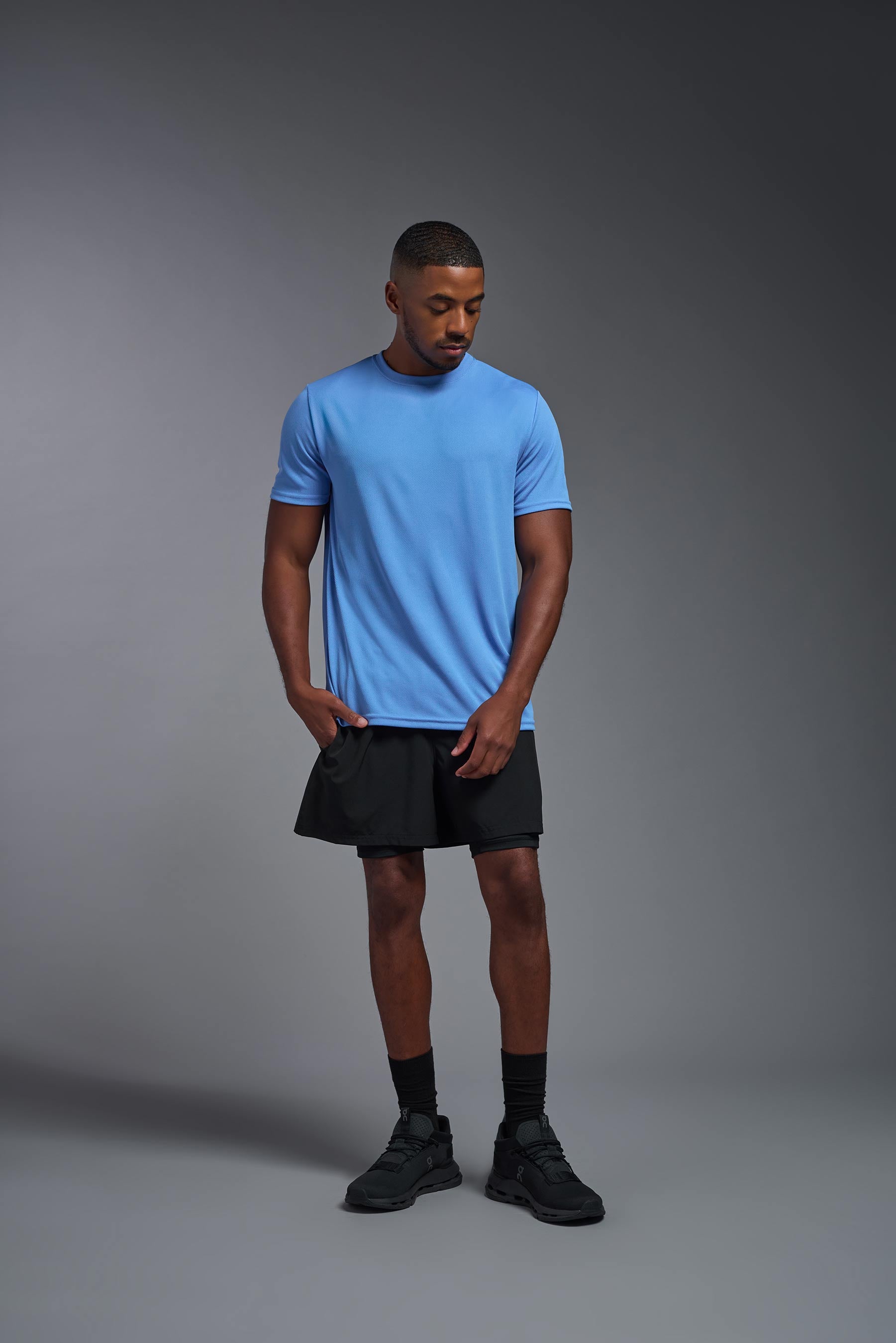 A male model wearing the men's Oxymesh Crewneck Tech Tee in the color carolina blue made out of 100% polyester, showing the relaxed fit from a front view. This shirt is breathable, wicks away moisture, quick-dries, and is made in the USA. #carolina-blue