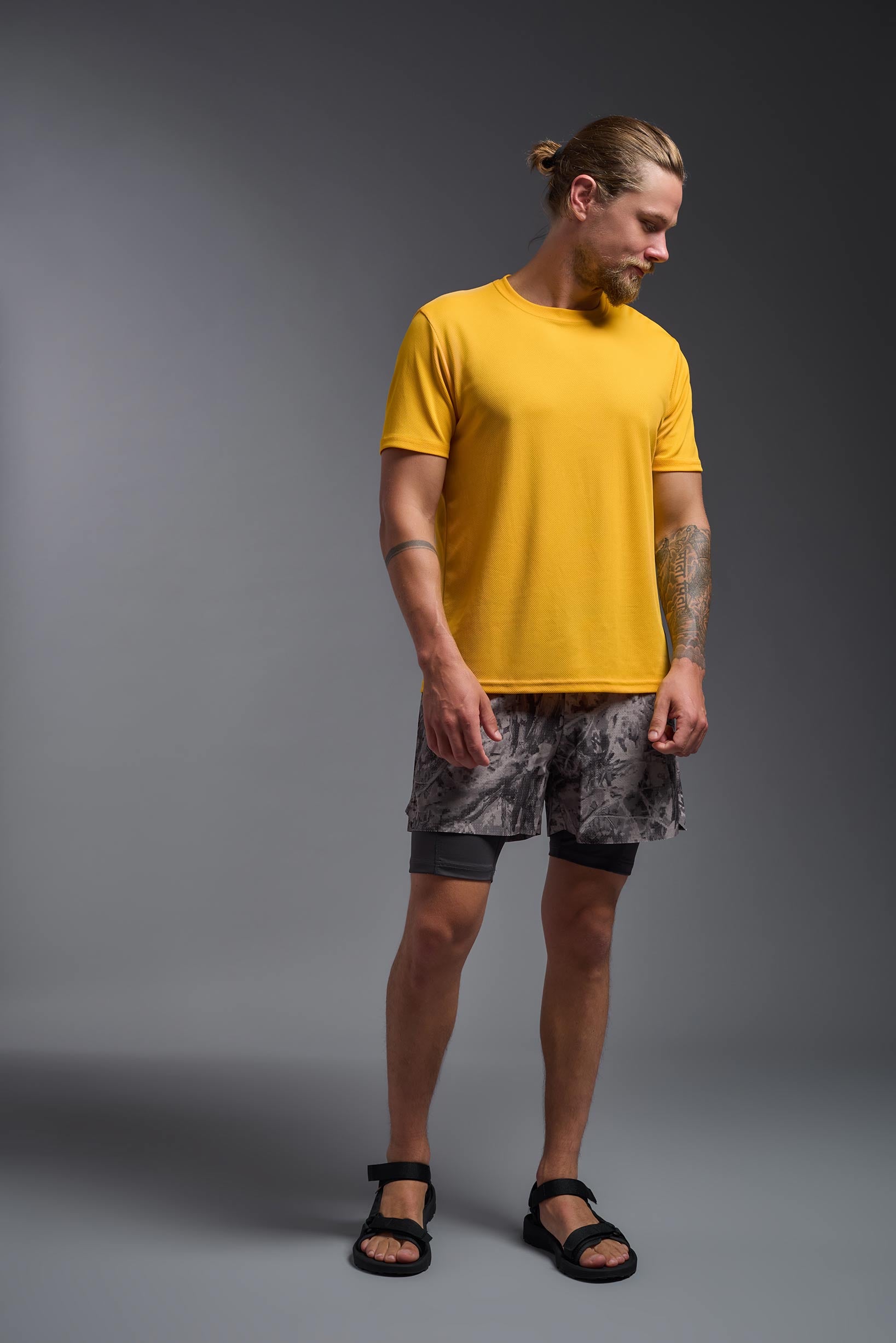 A male model wearing the men's Oxymesh Crewneck Tech Tee in the color gold, made out of 100% polyester, showing the relaxed fit from a front view. This shirt is breathable, wicks away moisture, quick-dries, and is made in the USA. #gold