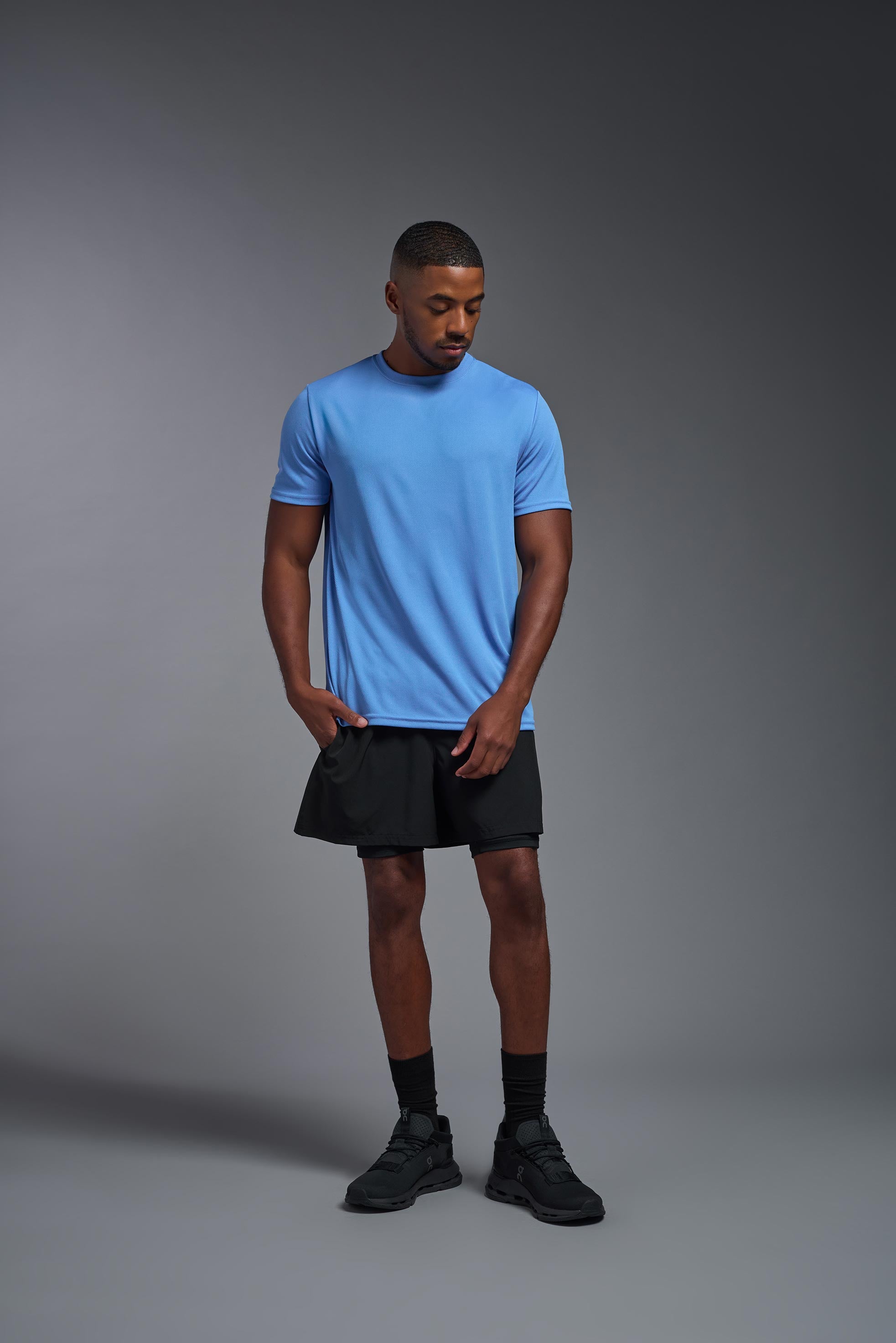 A male model wearing the men's Oxymesh Crewneck Tech Tee Imported Version in the color carolina blue, made out of 100% polyester, showing the relaxed fit from a front view. This shirt is breathable, quick-drying, moisture-wicking, and Imported for a better price on bulk apparel. #carolina-blue