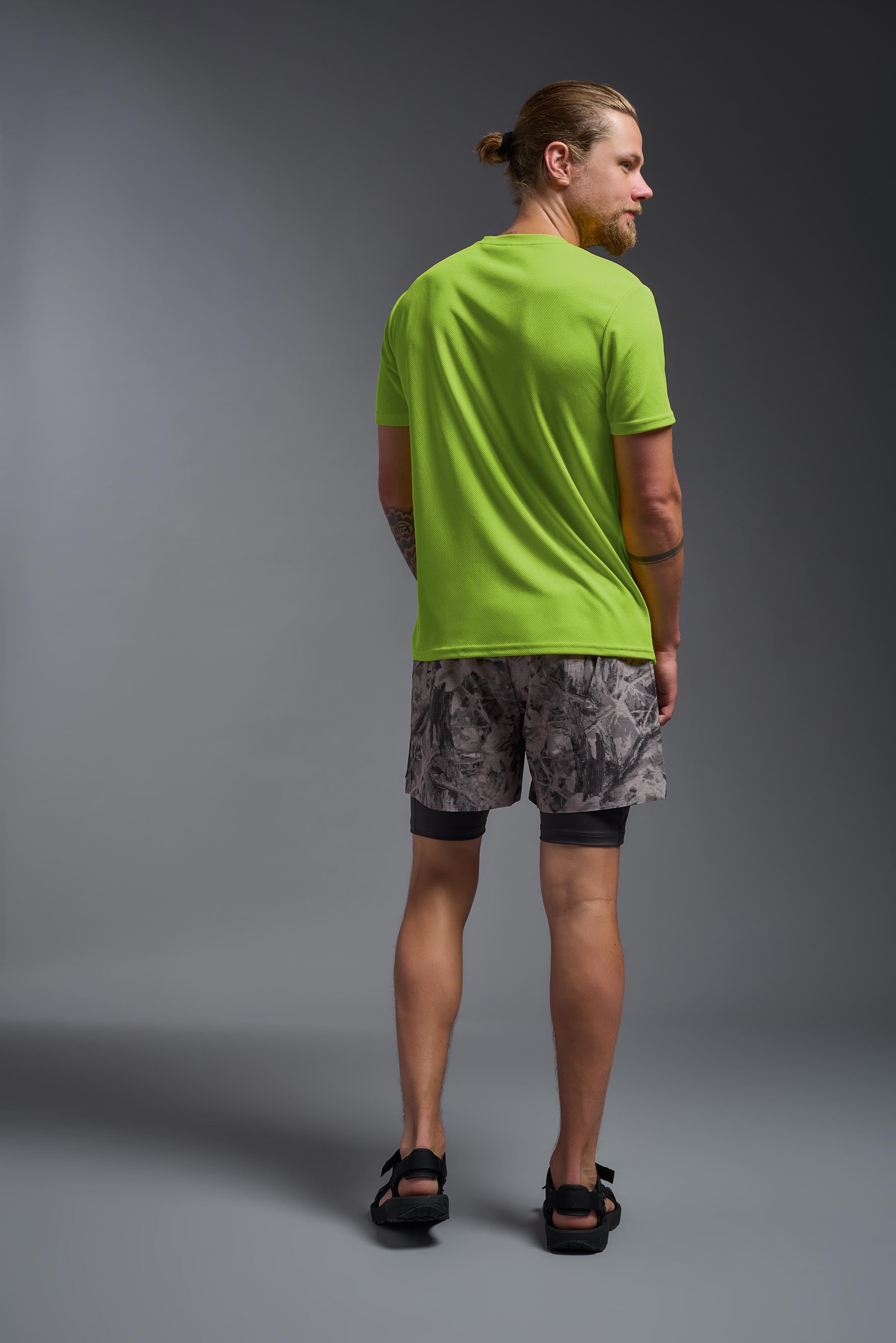 A male model wearing the men's Oxymesh Crewneck Tech Tee in the color key lime made out of 100% polyester, showing the relaxed fit from a back view. This shirt is breathable, wicks away moisture, quick-dries, and is made in the USA. #key-lime