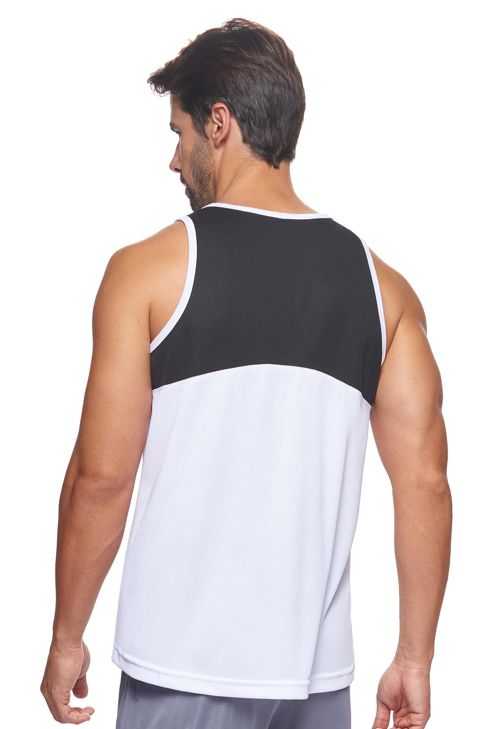 A male model wearing the men's Oxymesh Distance Tank  in the color block white and black, made out of 100% polyester, showing the relaxed fit from a back view. This tank is quick-drying, moisture-wicking, with up to 30 UV protection and made in the USA. #white