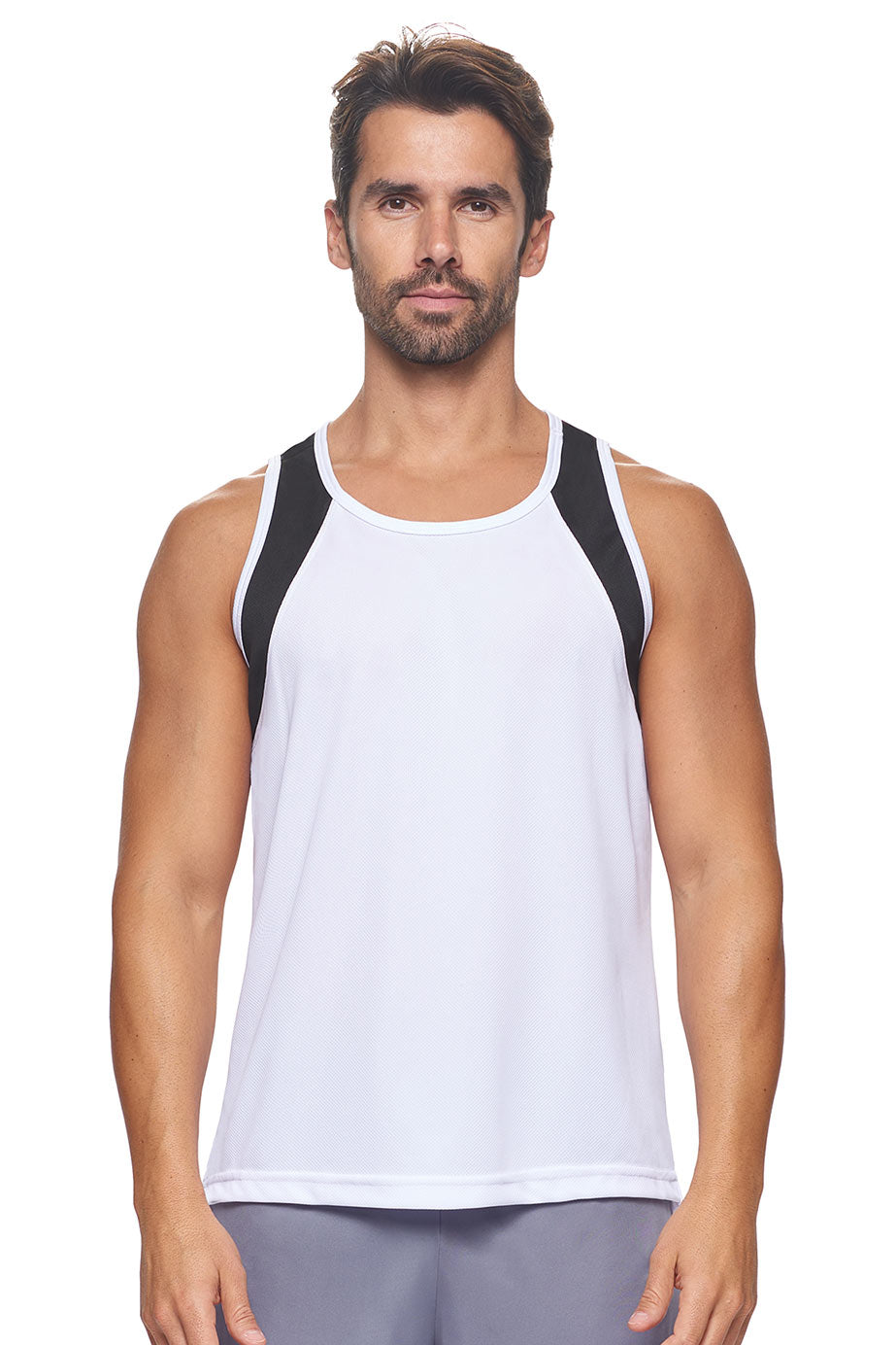 A male model wearing the men's Oxymesh Distance Tank  in the color block white and black, made out of 100% polyester, showing the relaxed fit from a front view. This tank is quick-drying, moisture-wicking, with up to 30 UV protection and made in the USA. #white