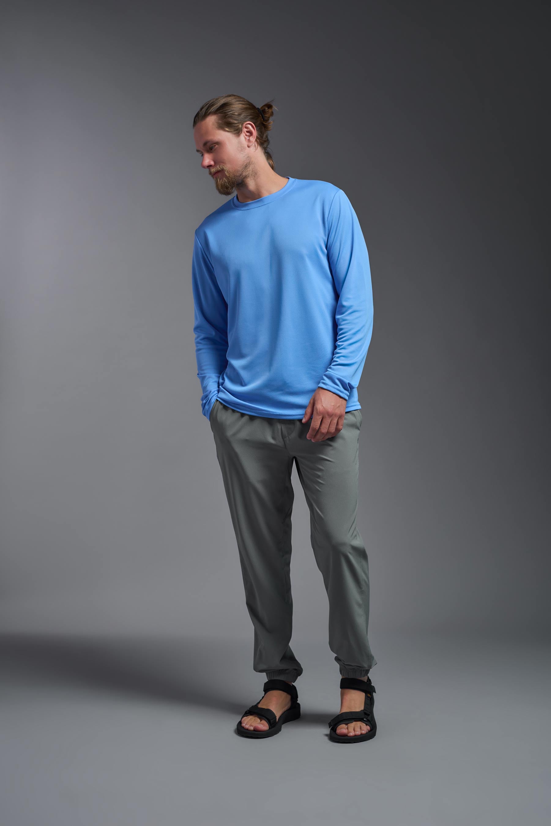 A male model wearing the men's Oxymesh Long Sleeve Tech Tee in the color carolina blue made out of 100% polyester, showing the relaxed fit from a front view. This shirt is breathable, quick-drying, moisture-wicking, and made in the USA. #carolina-blue