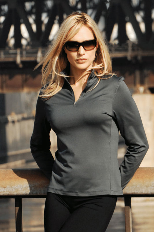 Woman model with blonde hair and sunglasses wearing the 1/4 Zip Pullover Training Top in the color charcoal in an industrial setting. This Training top is moisture-wicking and made in the USA #charcoal