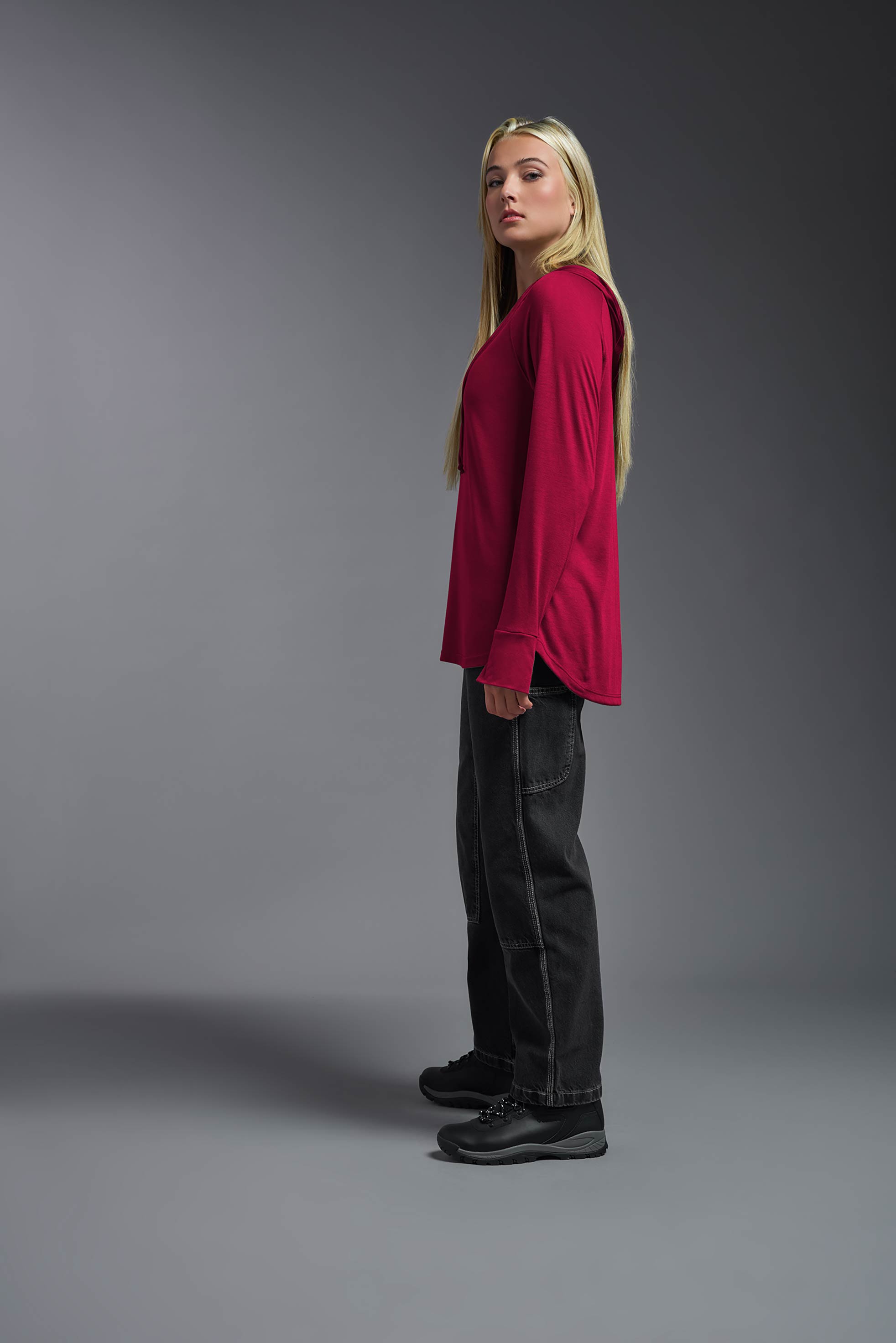 scarlet, made out of 100% filament polyester, showing the relaxed fit from a side view. This long sleeve hoodie shirt is breathable, quick-drying, moisture-wicking, and made in the USA. #scarlet